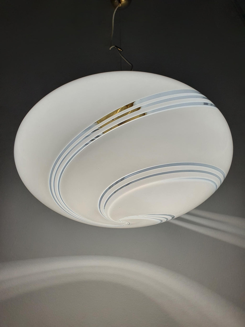 Vintage Murano white swirl glass globe pendant lit, warm soft white swirl glow, golden base, Scandinavian MCM dining room
