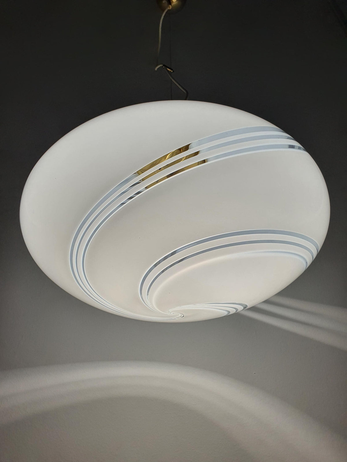 Vintage Murano white swirl glass globe pendant lit, warm soft white swirl glow, golden base, Scandinavian MCM dining room