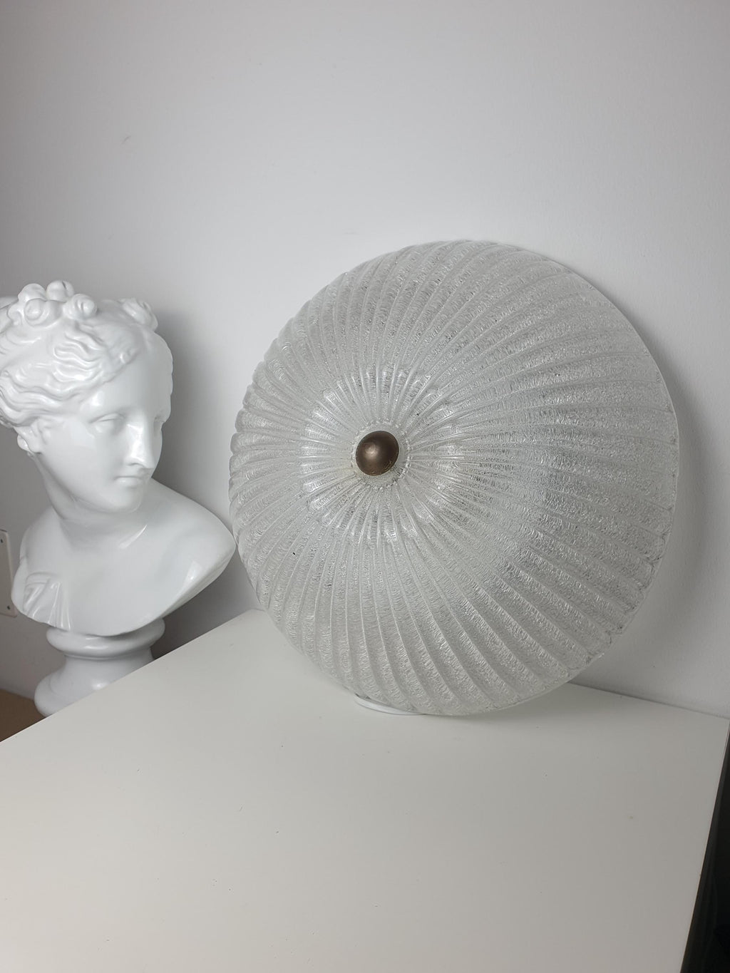 Vintage Venetian shell flush mount lit, sparkling ribbed glass reflections, soft diffused glow, Art Deco interior