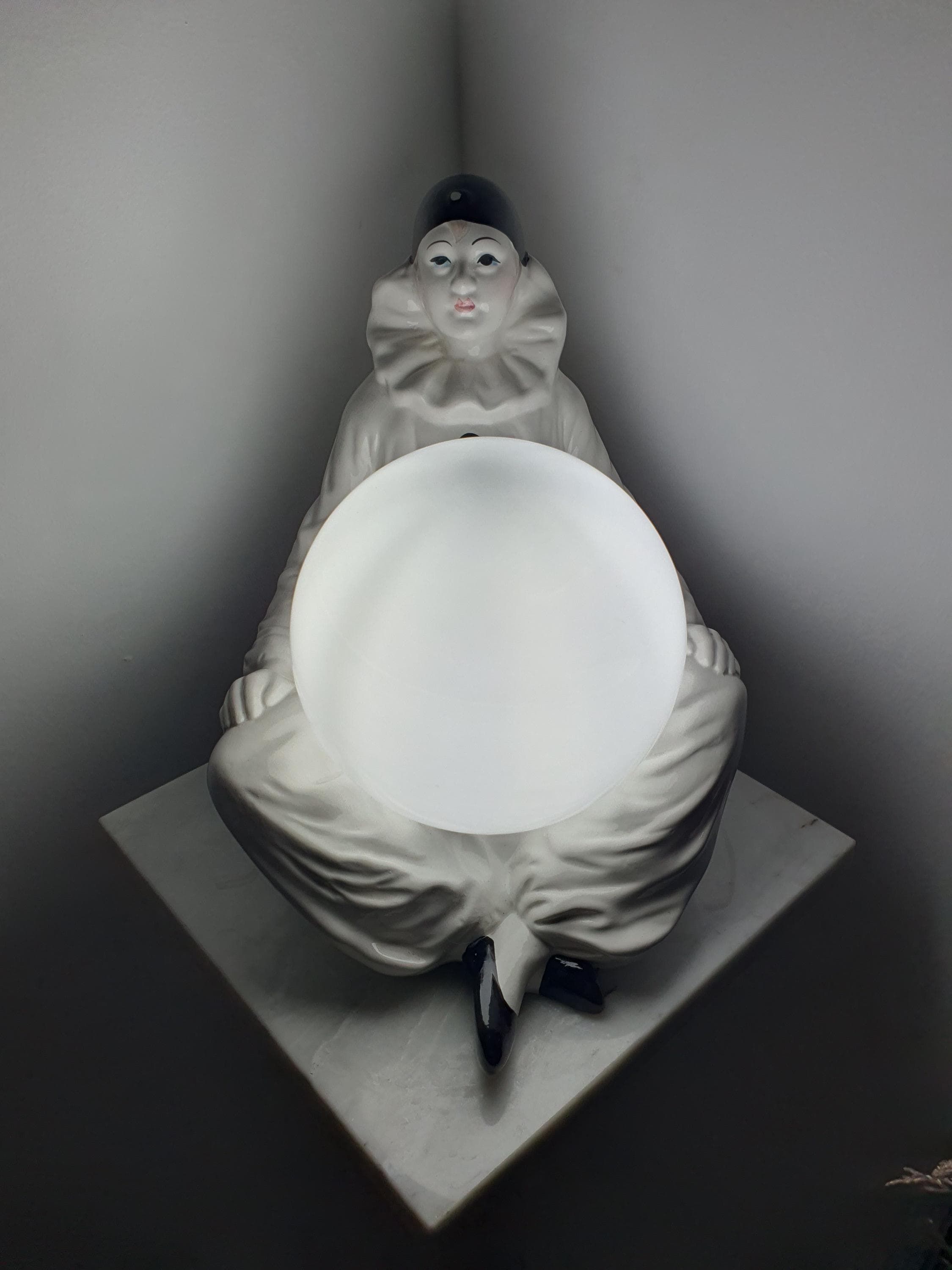 Vintage Italian Pierrot clown ceramic lamp front view, expressive sad clown figurine, white globe shade, theatrical Italian design