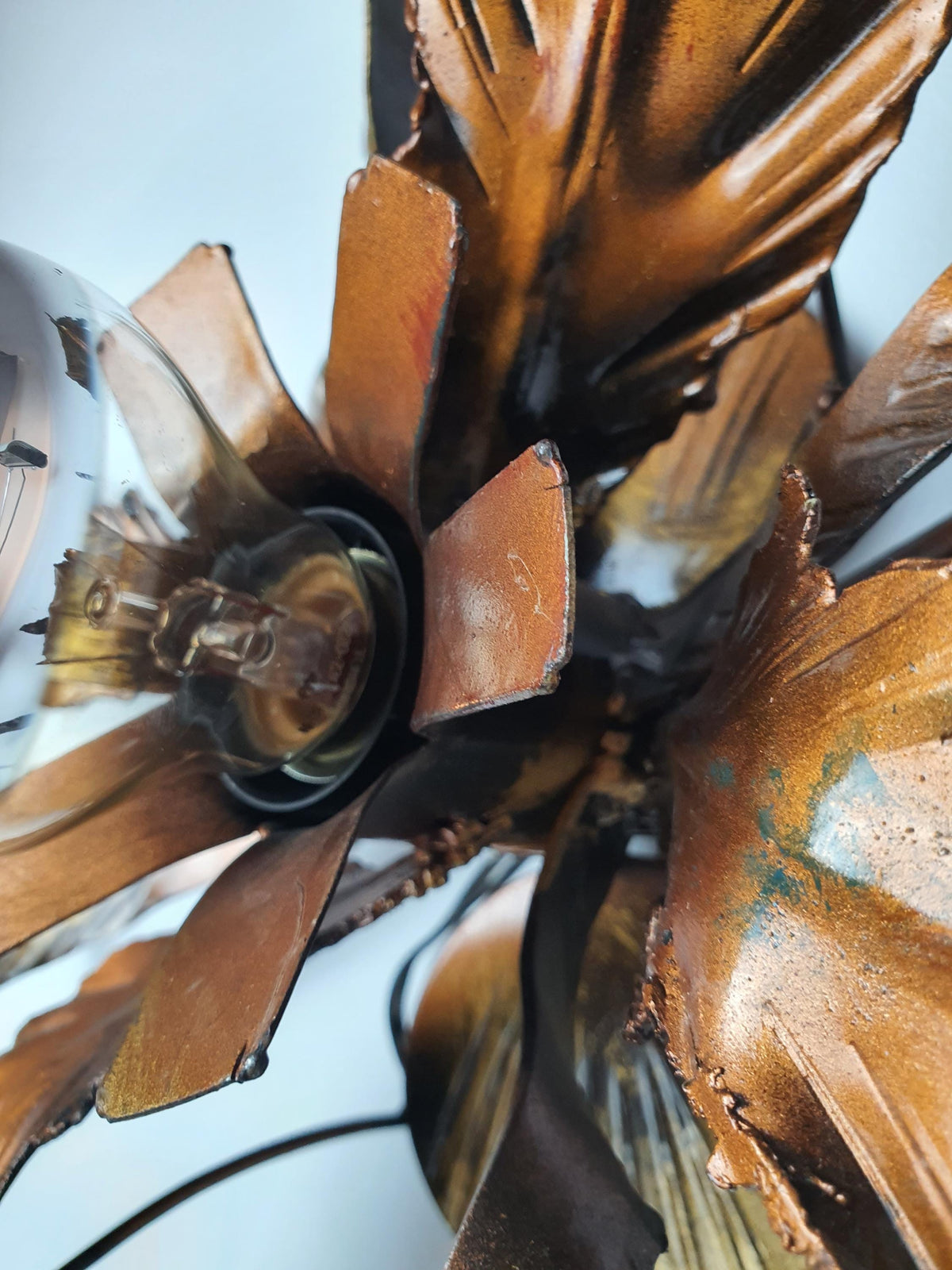 Sculptural leaf arrangement on a vintage botanical wall or ceiling fixture
