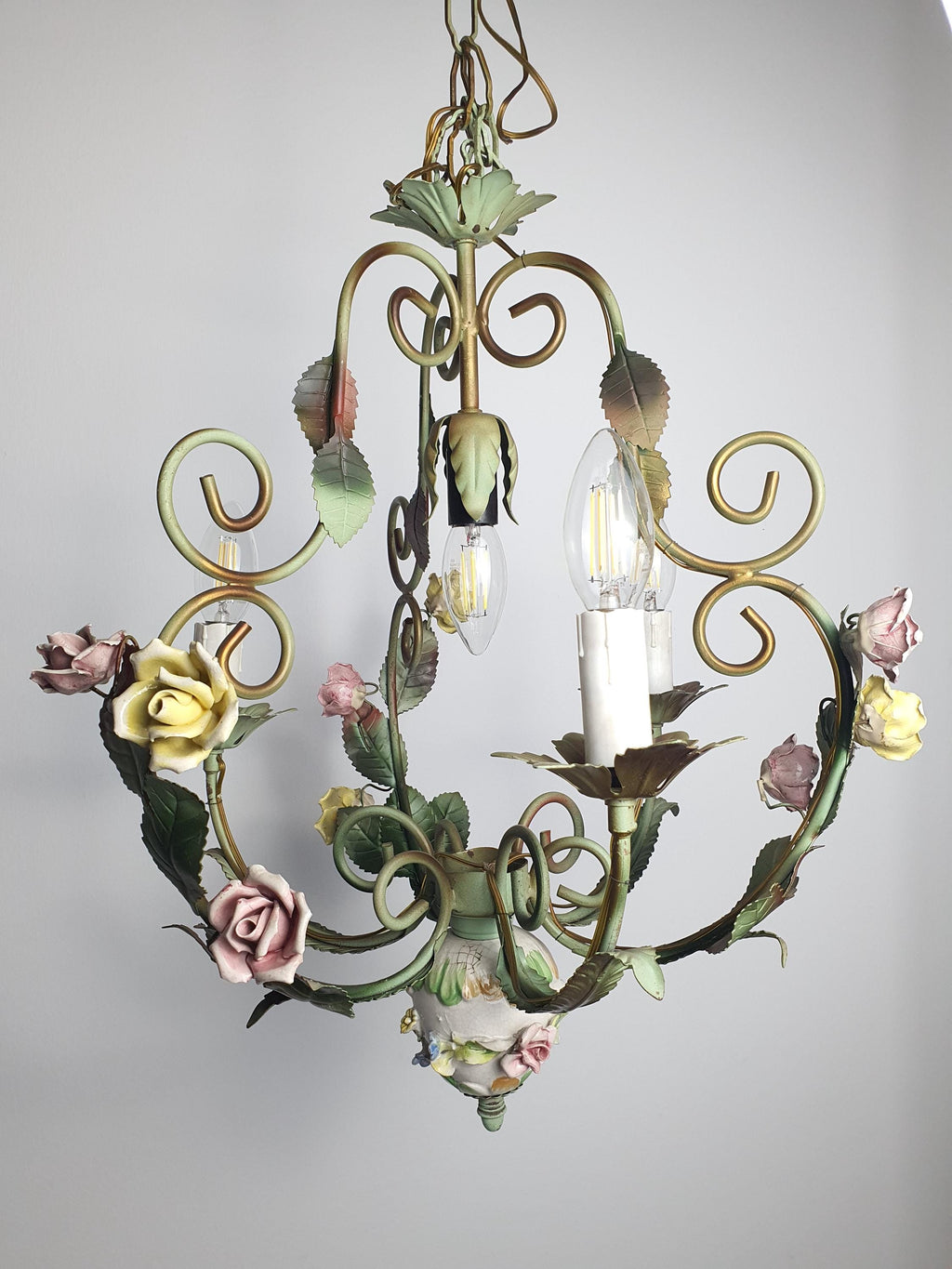 Close-up of hand-applied porcelain pink and yellow roses on vintage Italian tole chandelier