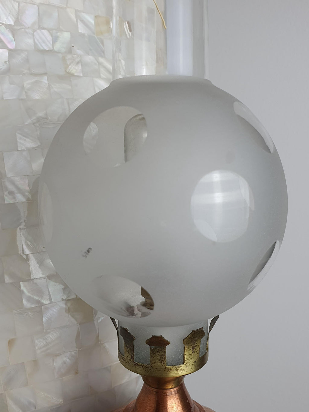 Close-up of frosted and clear spotted glass shade on vintage 1950s Italian copper oil lamp, decorative spotted pattern detail