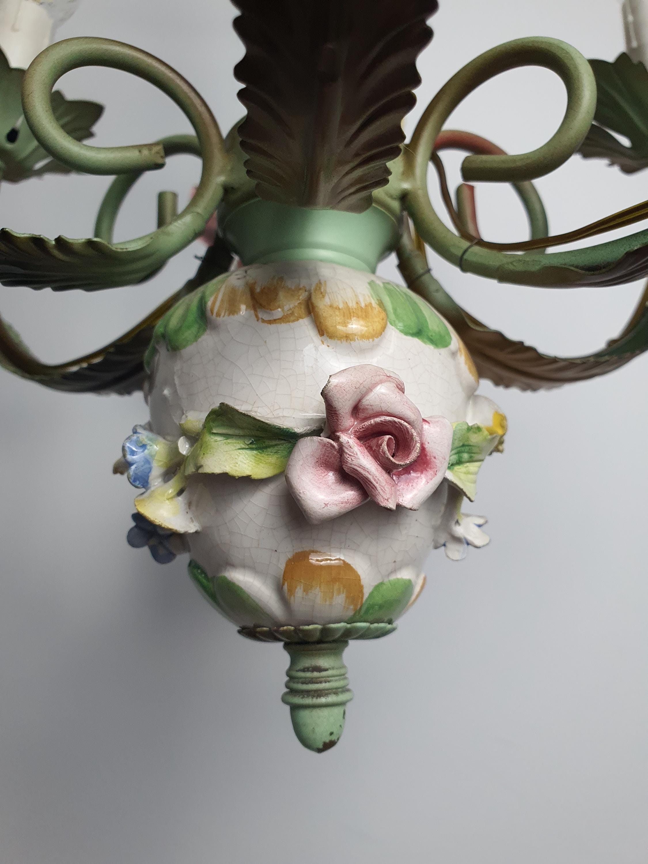 Vintage Italian floral chandelier lit, soft ambient glow, porcelain roses detail