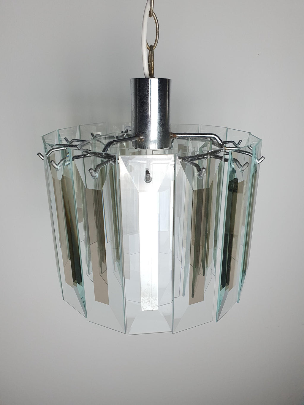 Close-up of aged chrome frame with oxidation patina on vintage Art Deco chandelier, authentic decades-old vintage character