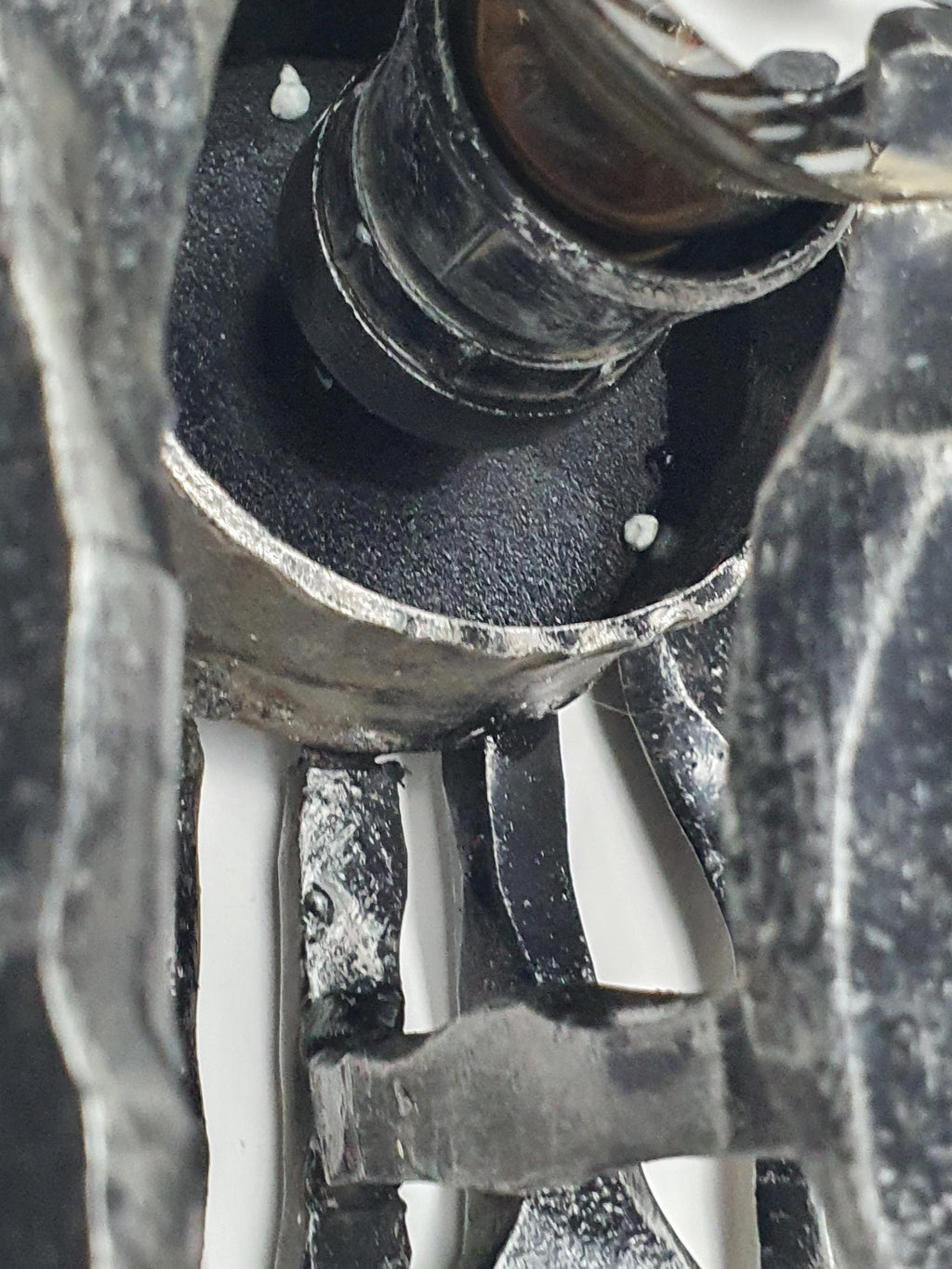 Chrome bulb holder detail against dark patinated wrought iron, 1970s Brutalist sconce