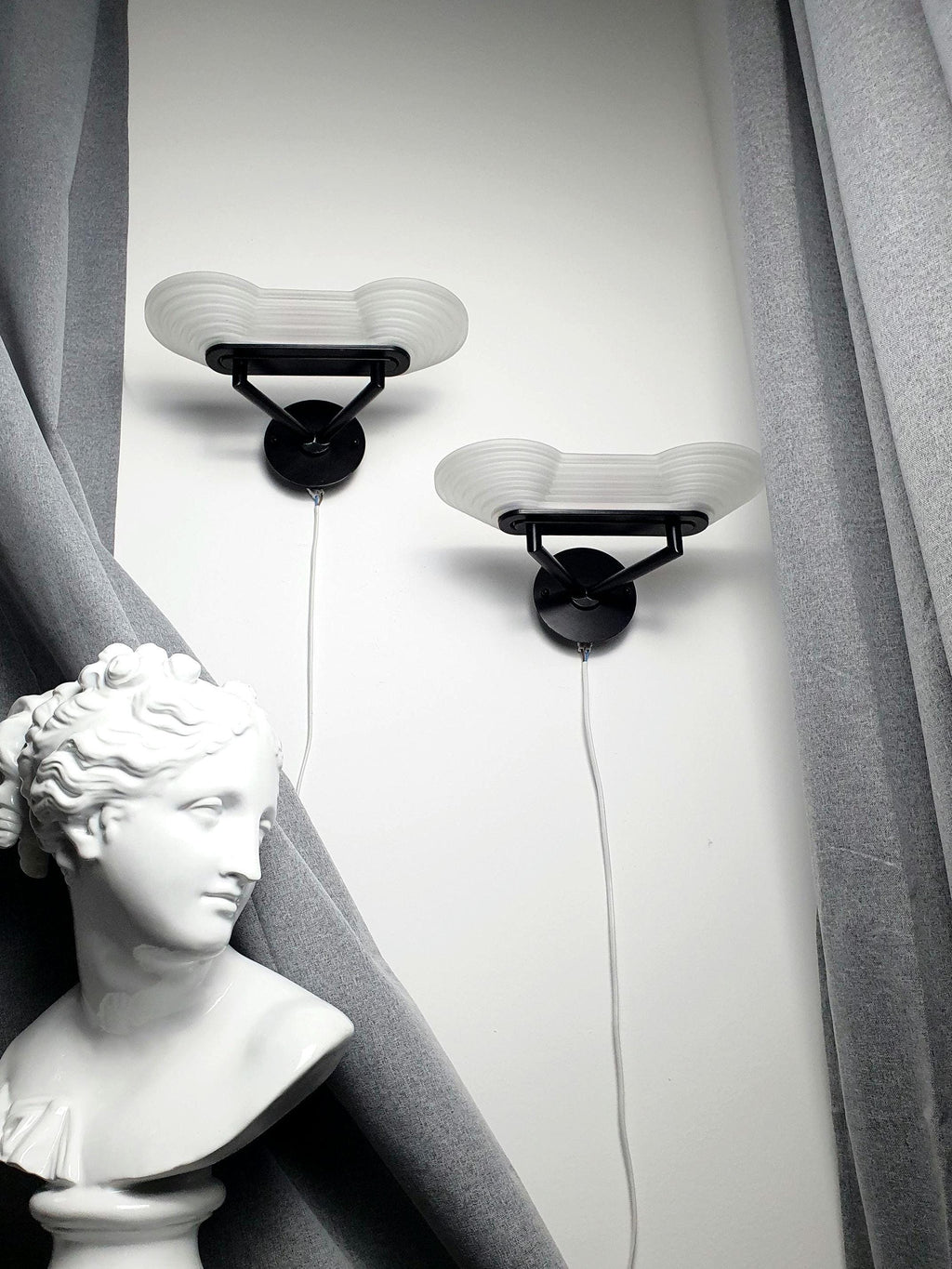 Pair of vintage Italian Memphis Postmodern wall lights, thick satin glass stepped pyramid diffusers, black metal bases, 1980s