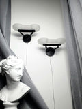 Pair of vintage Italian Memphis Postmodern wall lights, thick satin glass stepped pyramid diffusers, black metal bases, 1980s