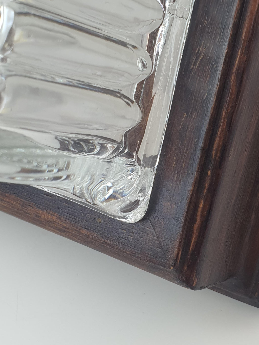 Close-up of deep ribbed relief surface on vintage Italian square stamped clear glass Brutalist light, wood frame detail