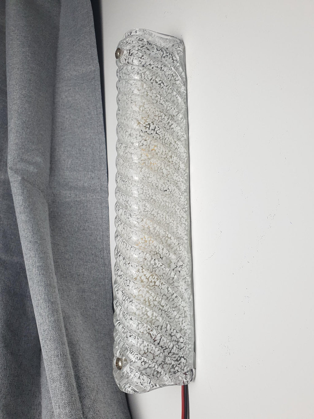 Detail of icy clear glass with scattered white inclusions and deep vertical ribs, vintage Murano rectangular sconce