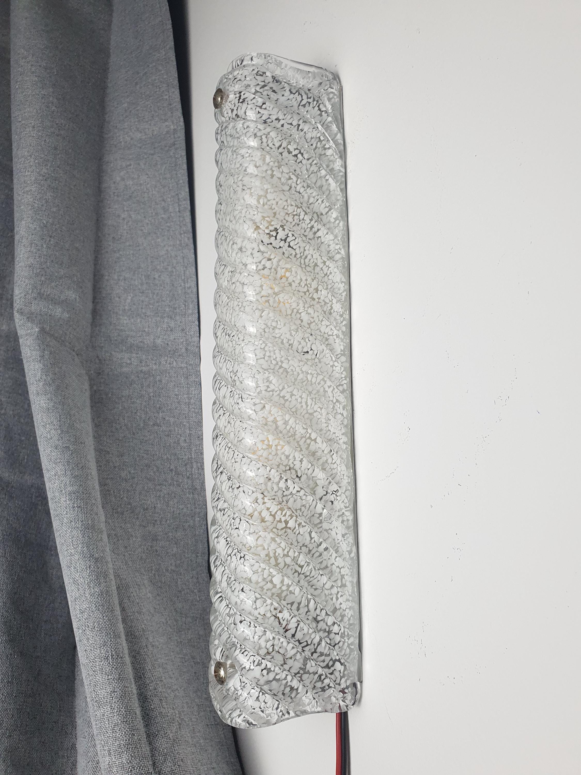 Detail of icy clear glass with scattered white inclusions and deep vertical ribs, vintage Murano rectangular sconce