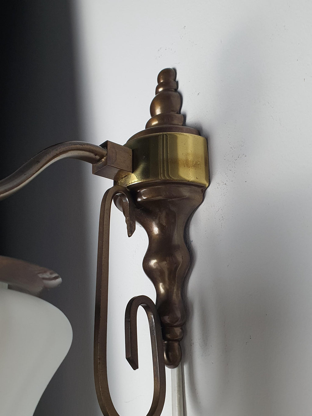 Close-up of brass base with patina on vintage Italian satin frosted flute wall sconce, warm brass detail