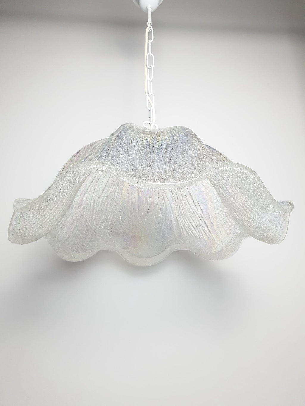 Vintage Murano iridescent tulip pendant installed above dining table, large sculptural form, rainbow light reflections