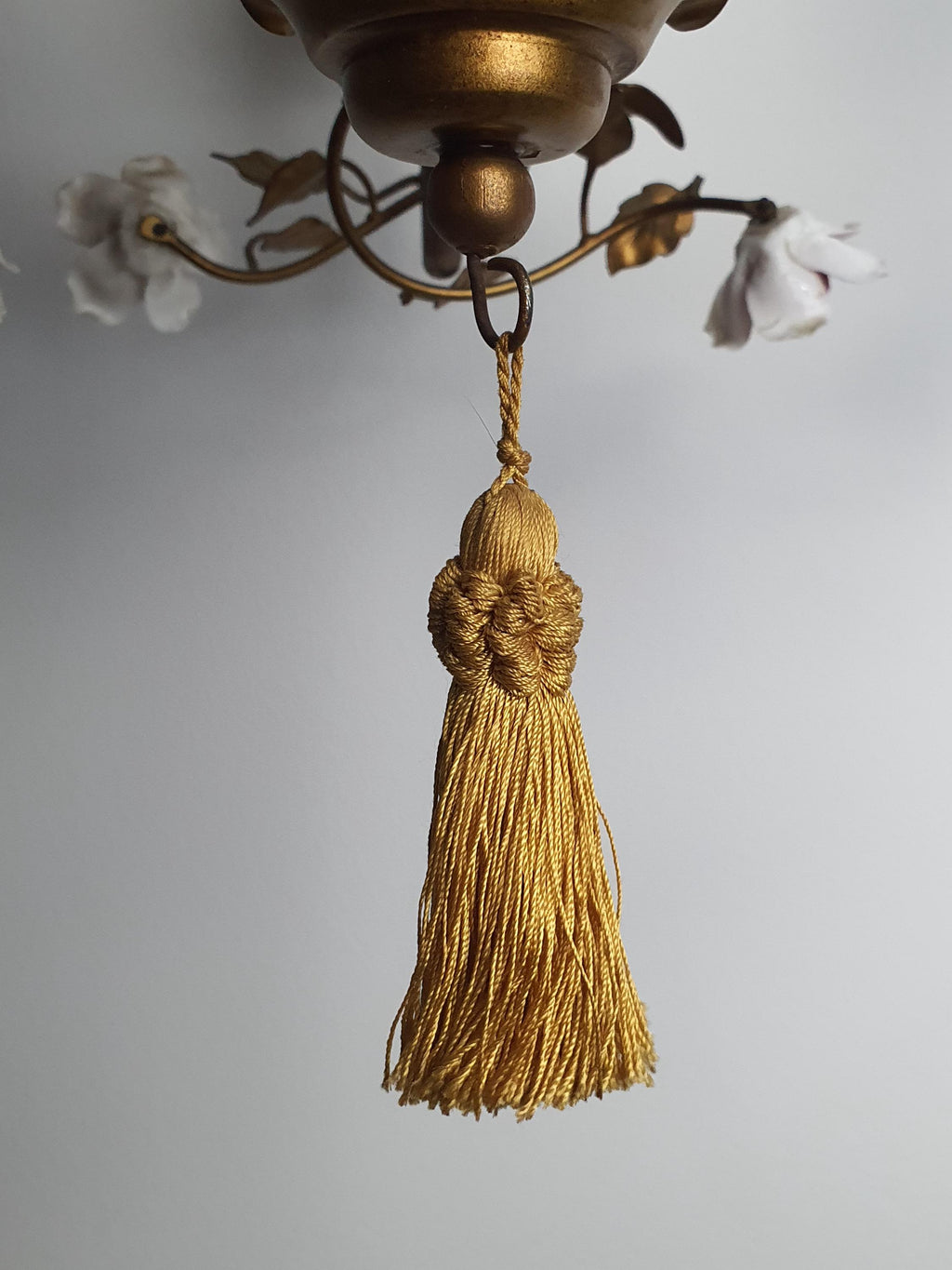 Age-related wear and patina on the chandelier’s bronze-toned metal frame
