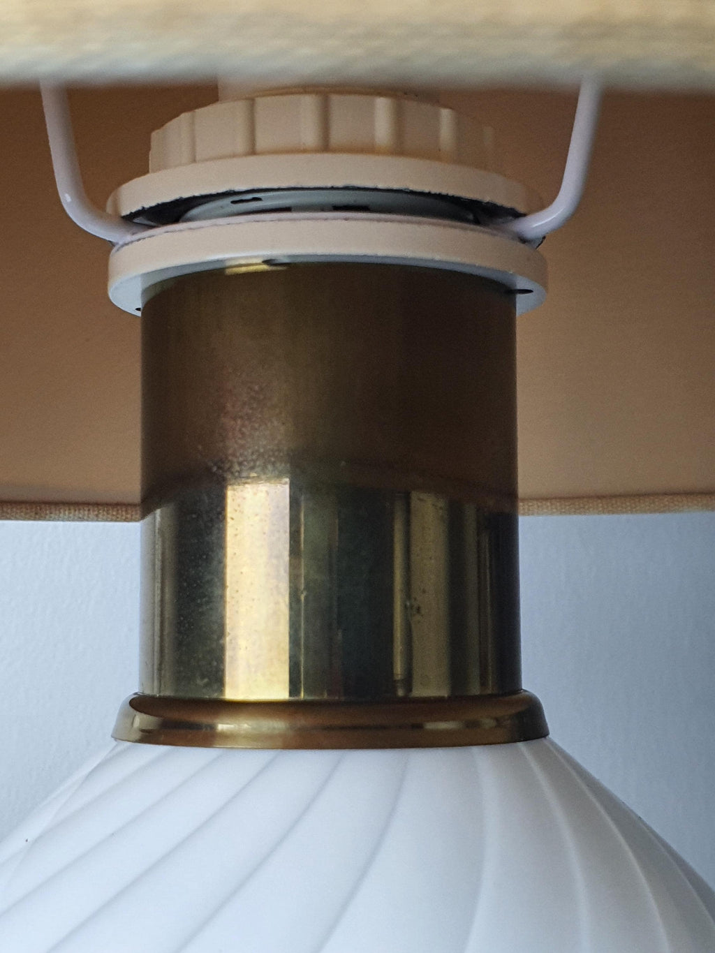 Close-up of brass base and details on vintage Murano white candy swirl bedside lamp, warm aged brass, vintage wear