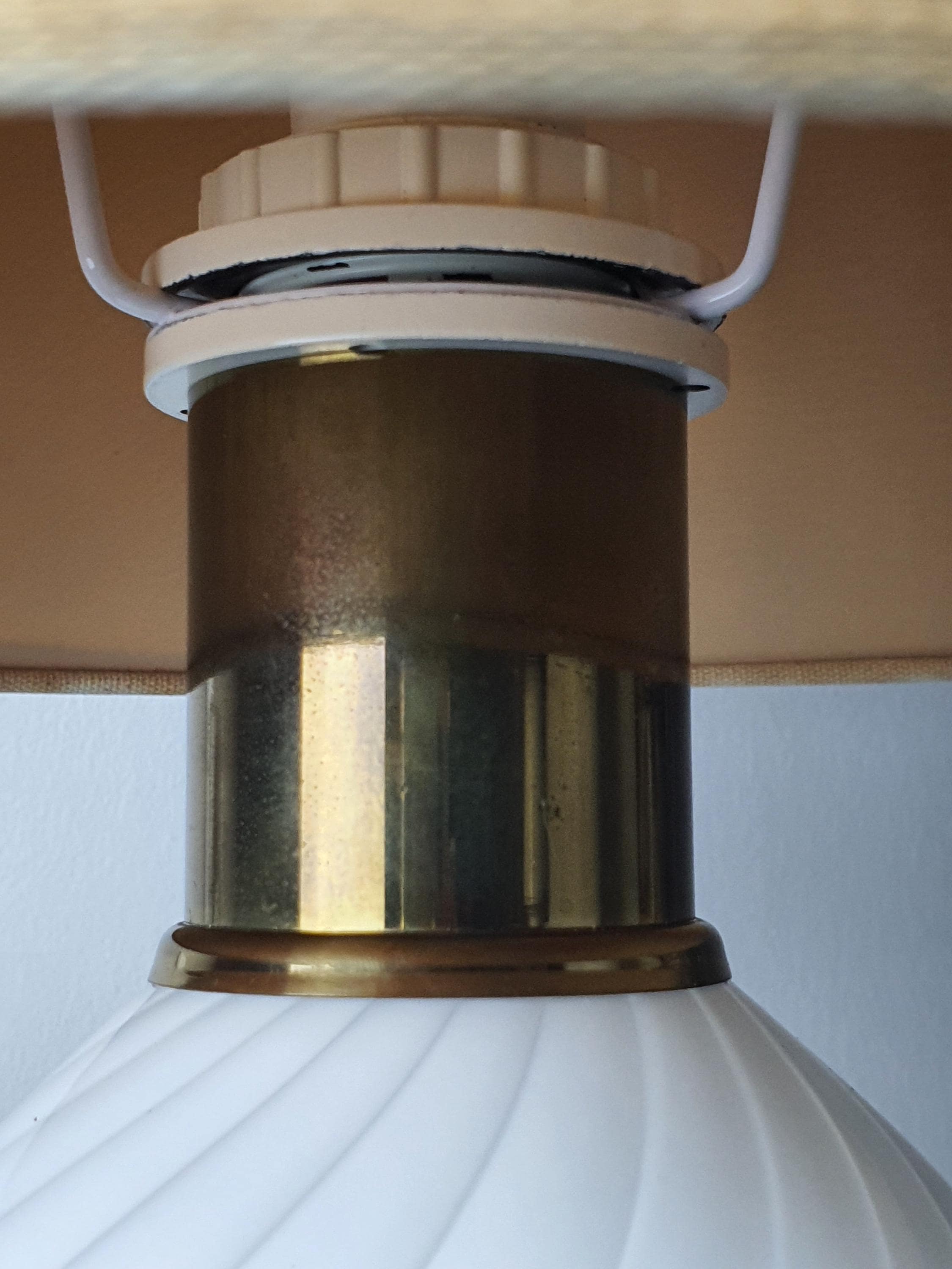 Close-up of brass base and details on vintage Murano white candy swirl bedside lamp, warm aged brass, vintage wear