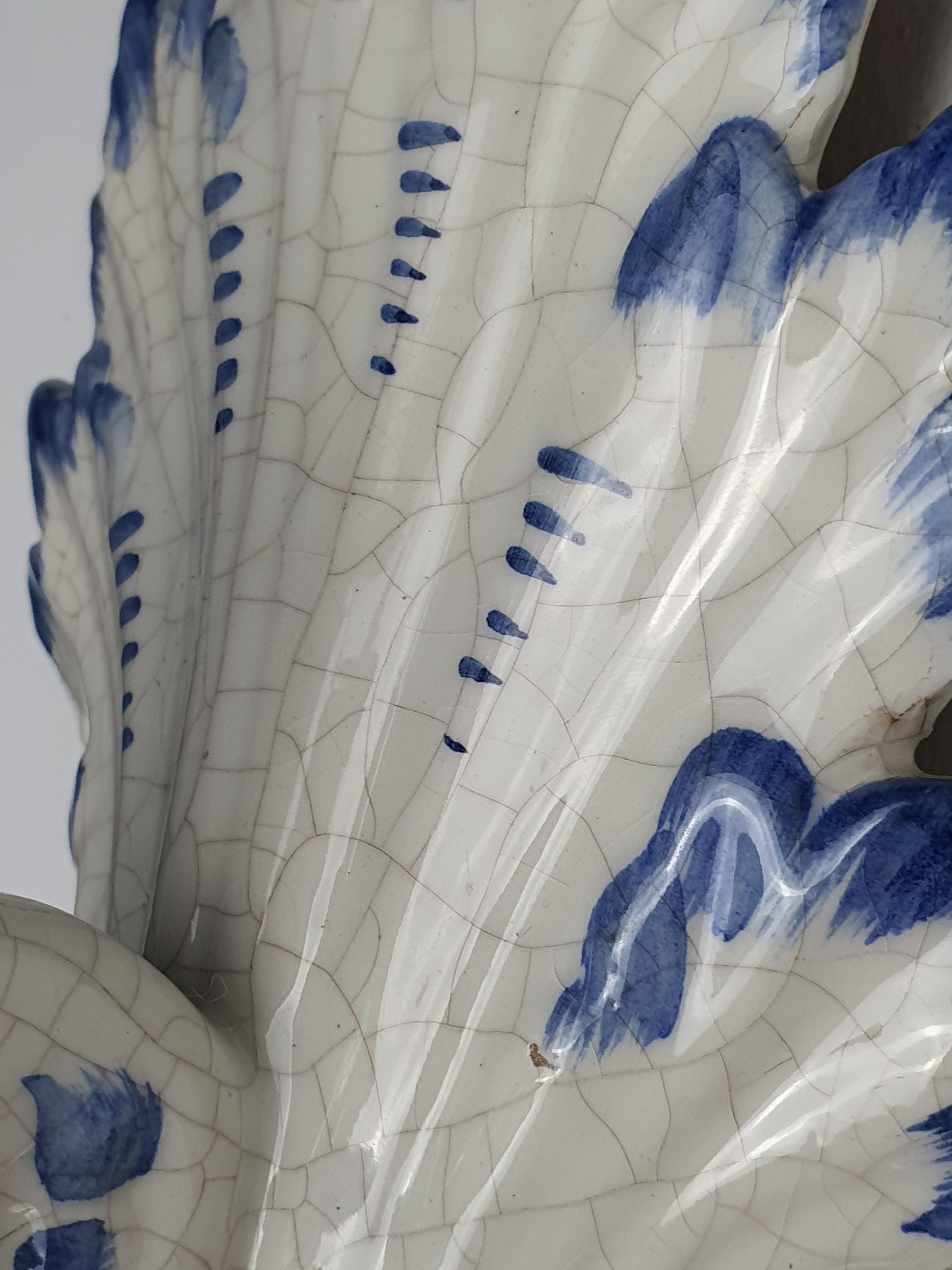 Close-up of hand-painted blue decorative details on vintage Italian Bassano white glazed ceramic wall sconce