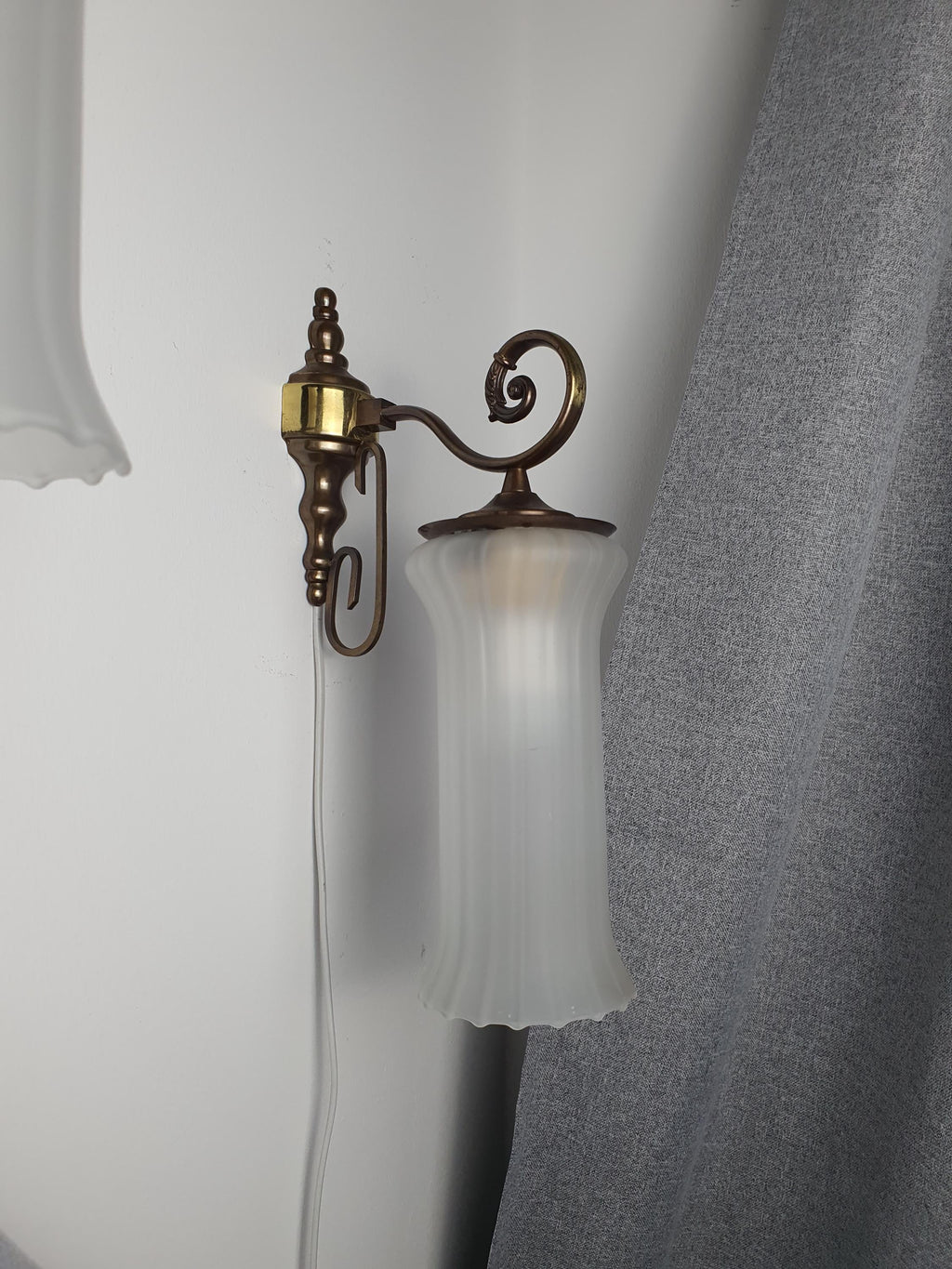 Vintage Italian satin frosted flute wall sconce facing upward, showing reversible hook mount installation, brass base