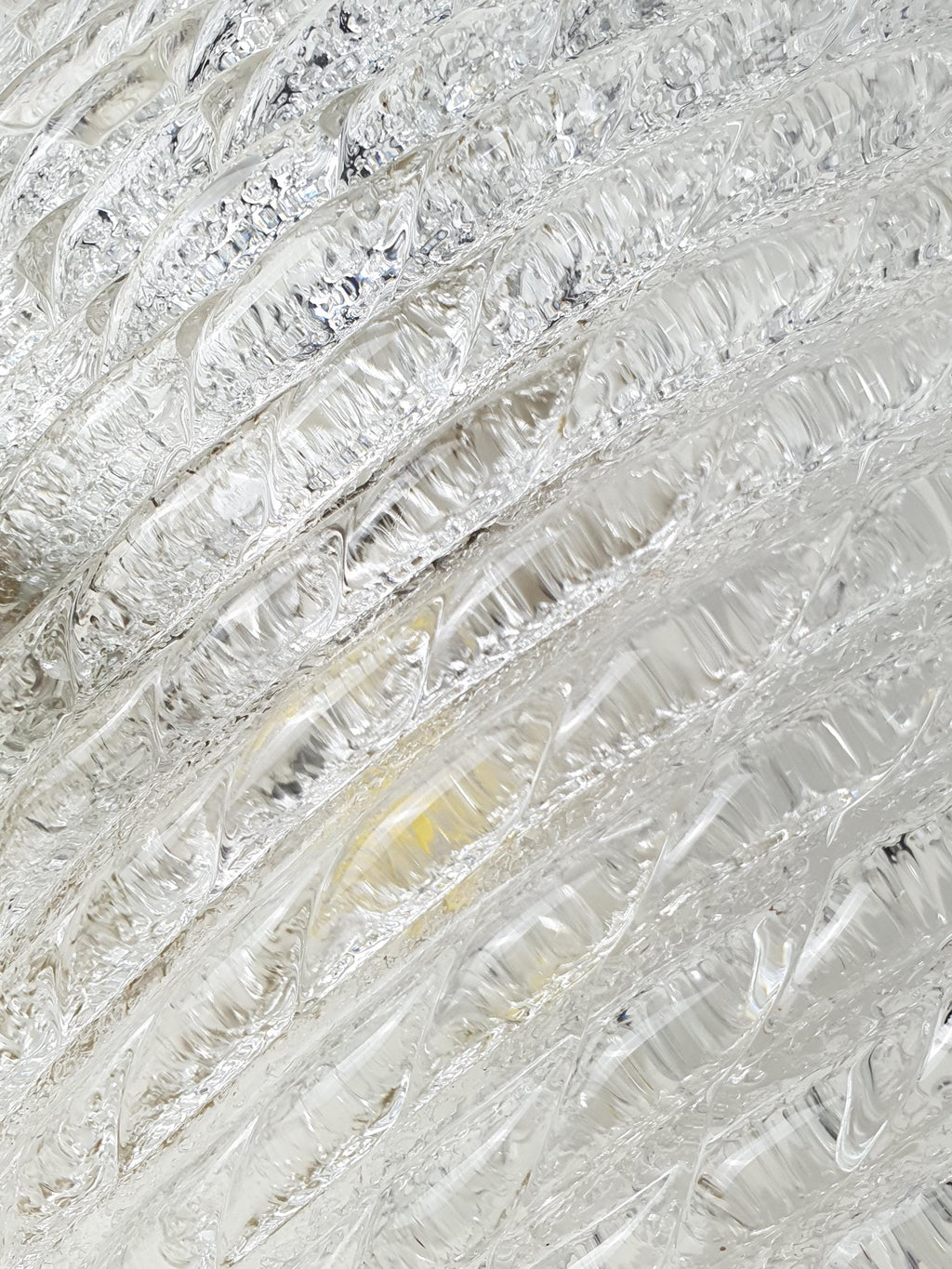 Close-up of thick ribbed iced glass texture on vintage Murano shell flush mount, deep ribbing light reflections