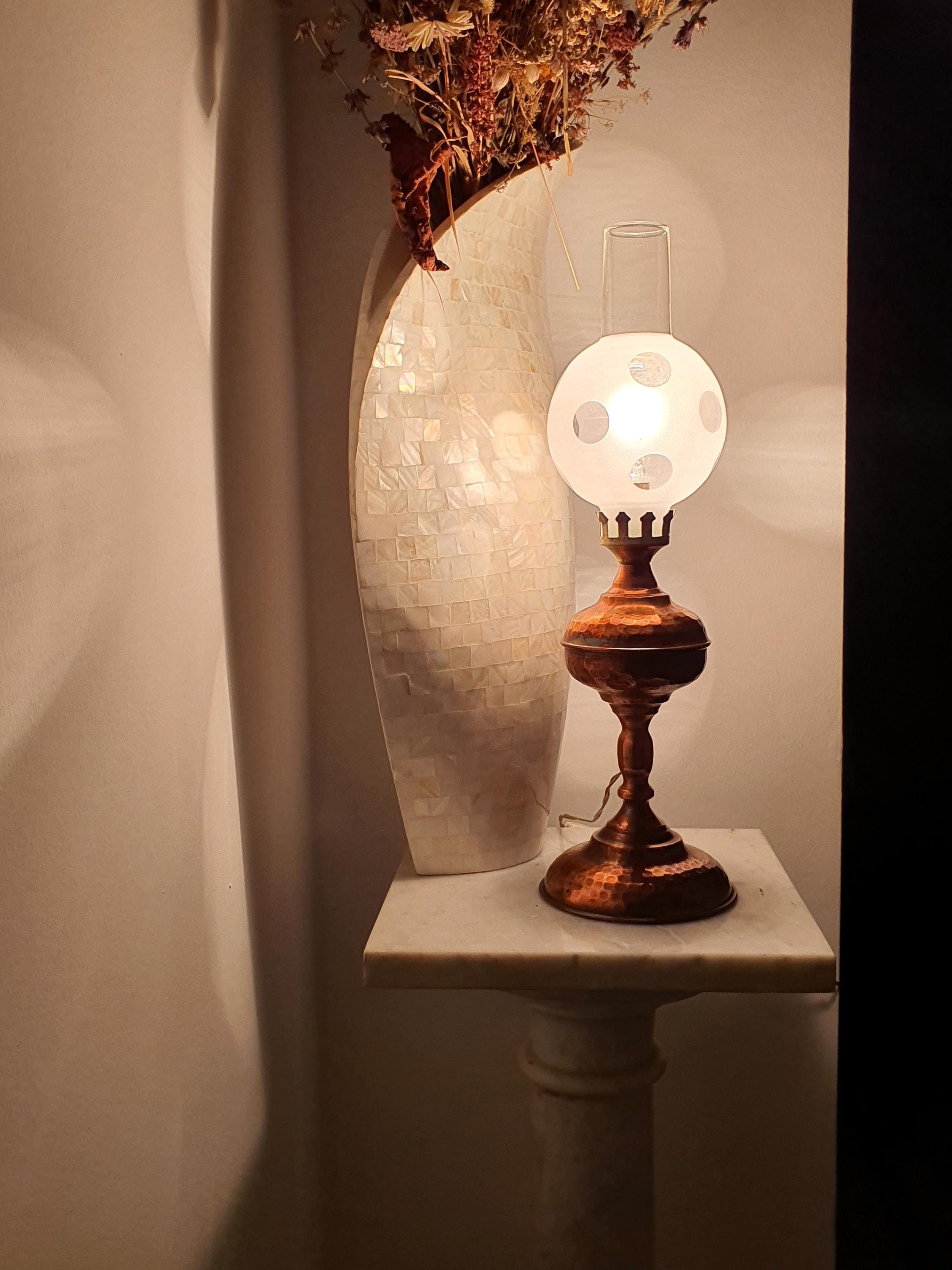 Vintage 1950s Italian copper oil lamp lit, warm spotted glass glow, aged copper body, romantic bedside accent light