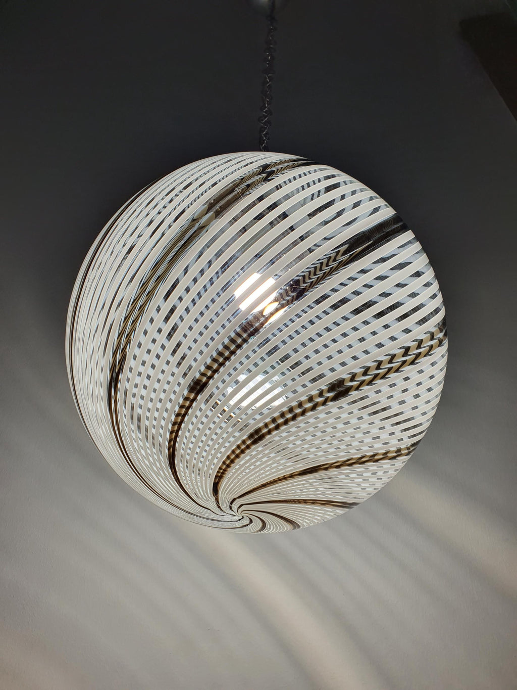 Detail of aged chrome wear and patina on vintage Murano filigrana globe pendant fitting