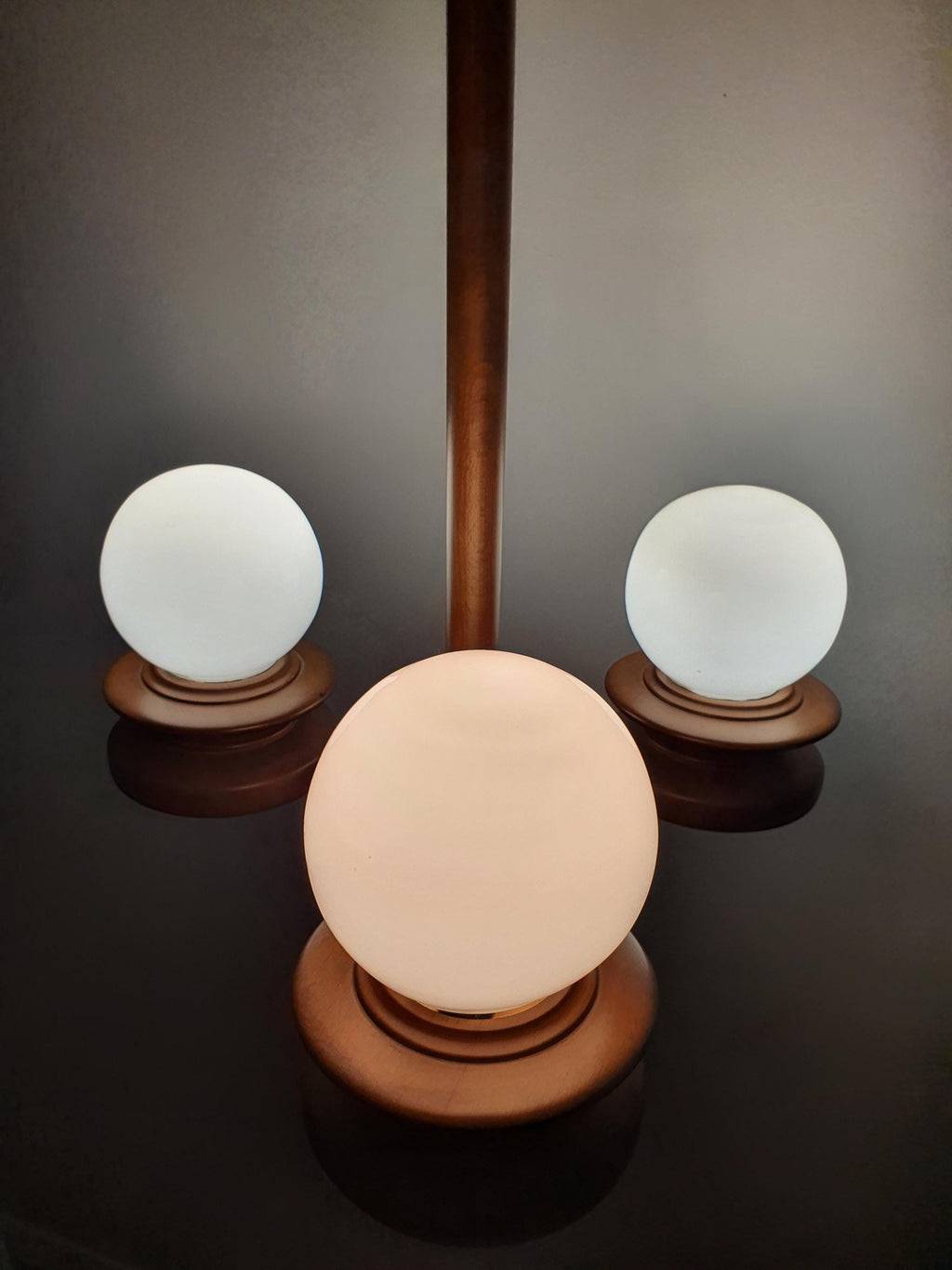 Vintage Space Age Sputnik chandelier in dining room, three milk glass globes, wood structure, warm Scandinavian MCM glow