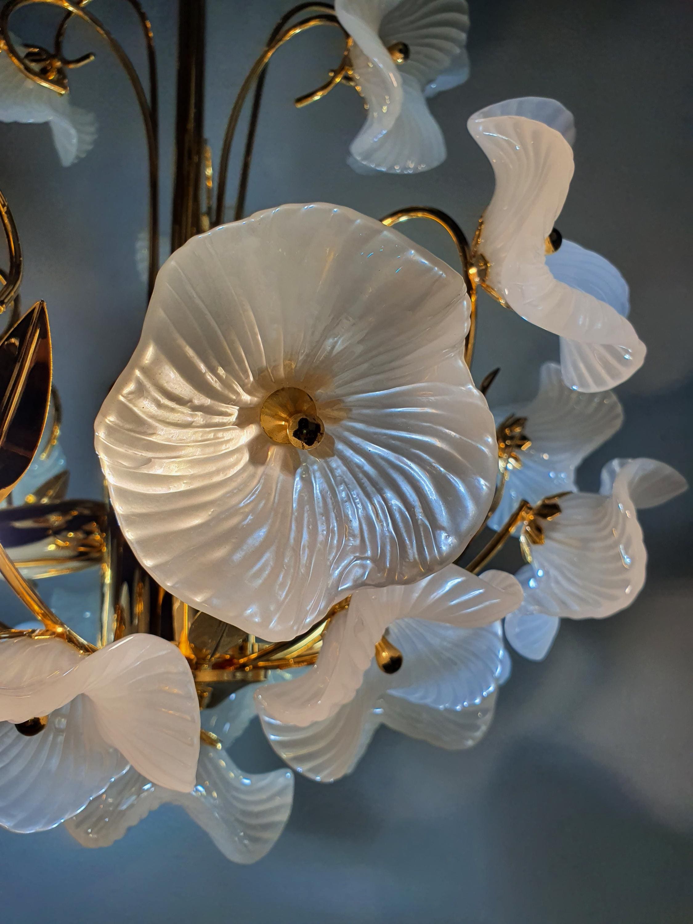Vintage Murano white flower bouquet chandelier in nursery, gentle white glass flower glow, gold frame, delicate romantic