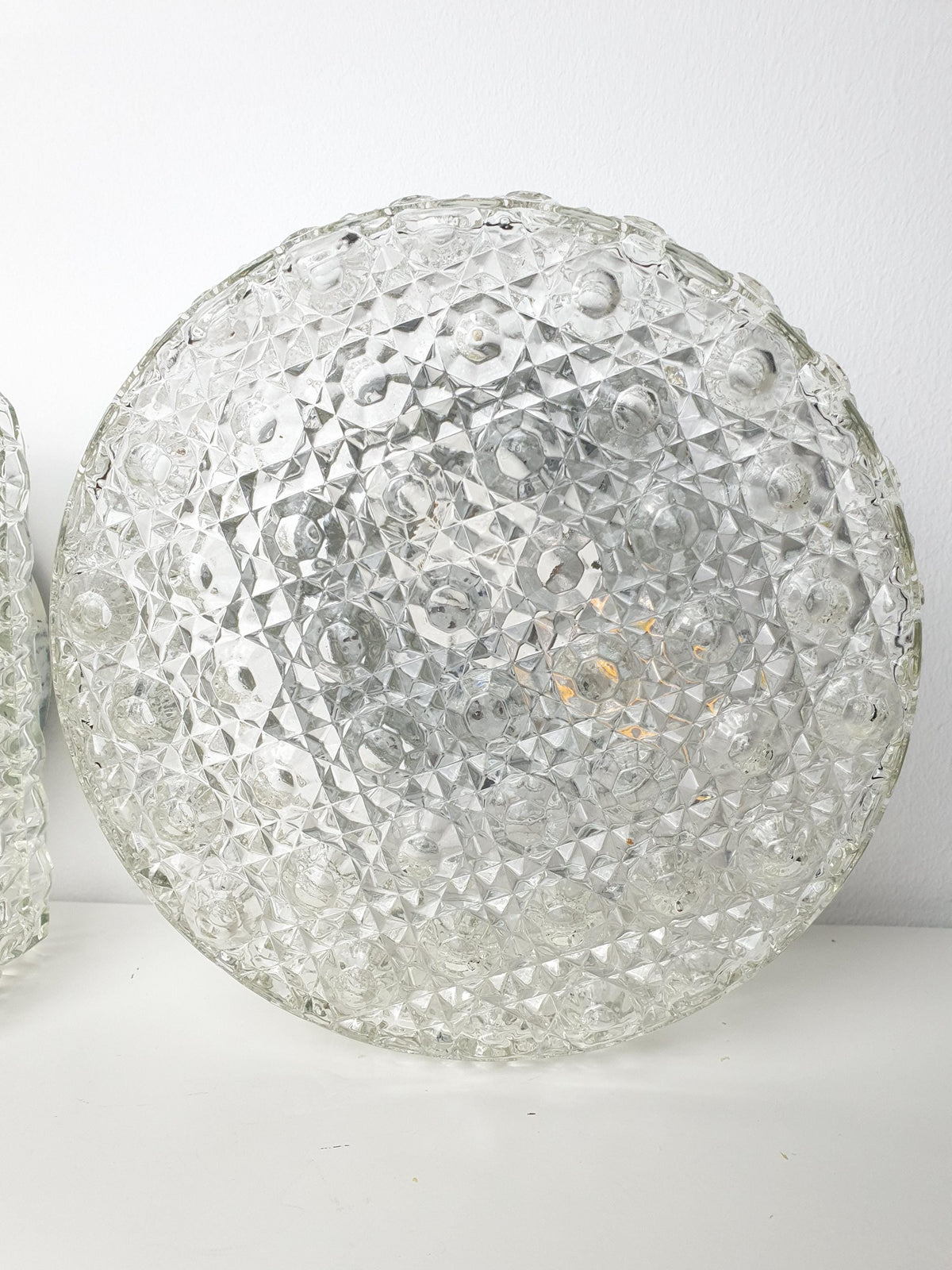 Round vintage wall sconce with thick textured clear glass
