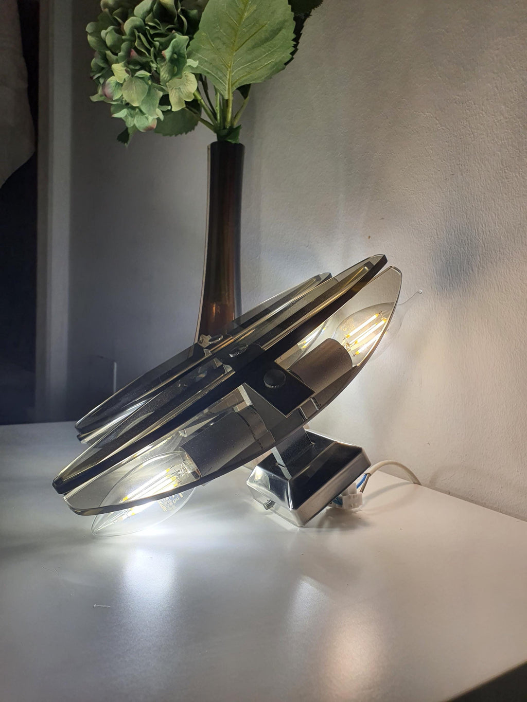 Applique vintage italienne Veca — verre fumé filtrant une lumière ambiante chaleureuse, allumée