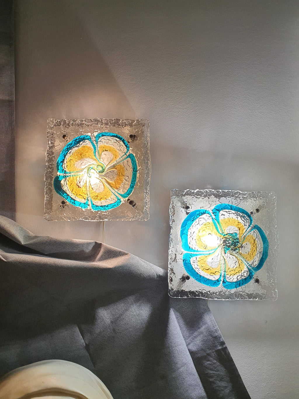 Pair of vintage Mazzega Murano floral sconces installed in living room, turquoise caramel glow, MCM Italian interior