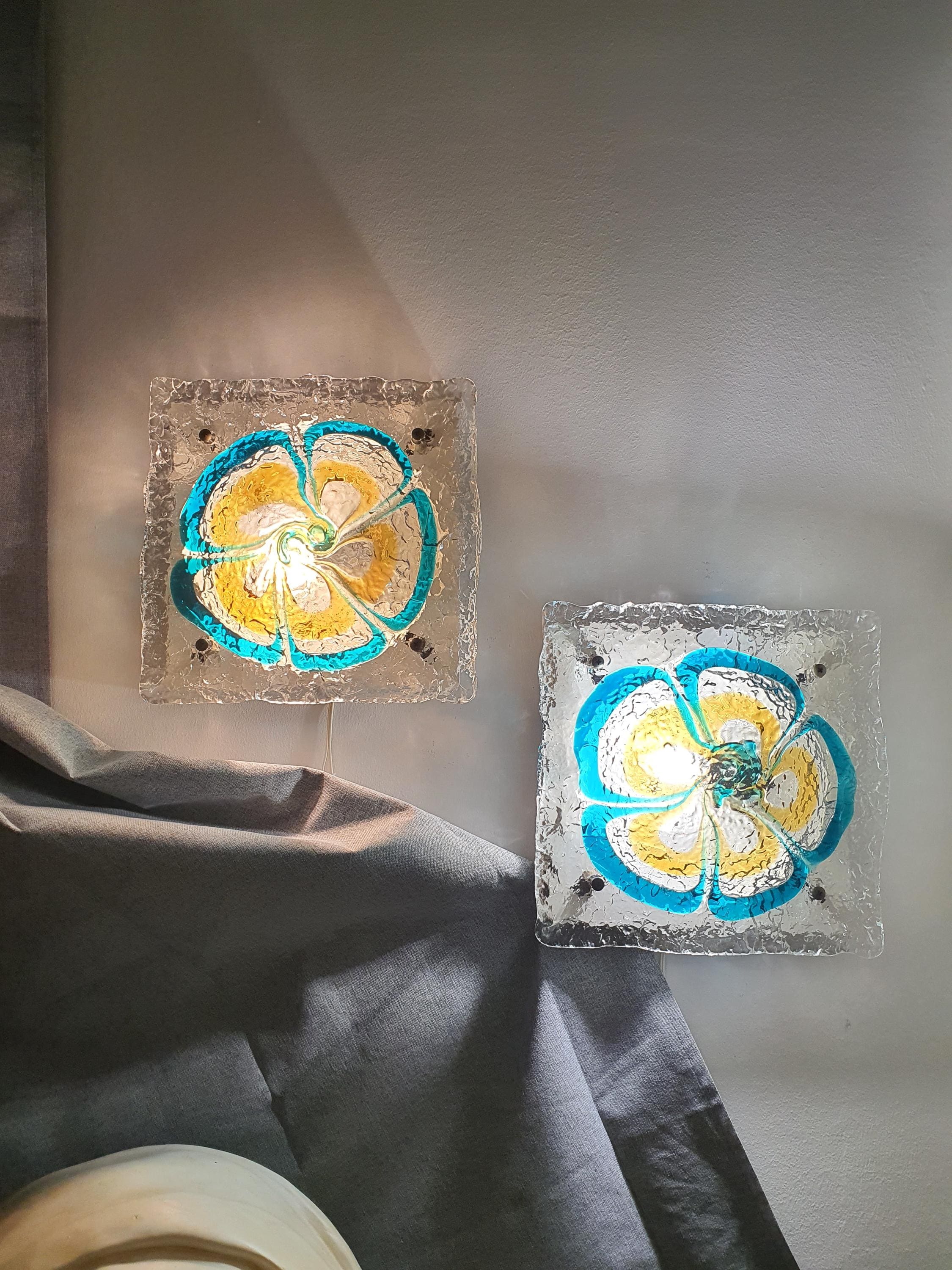 Pair of vintage Mazzega Murano floral sconces installed in living room, turquoise caramel glow, MCM Italian interior