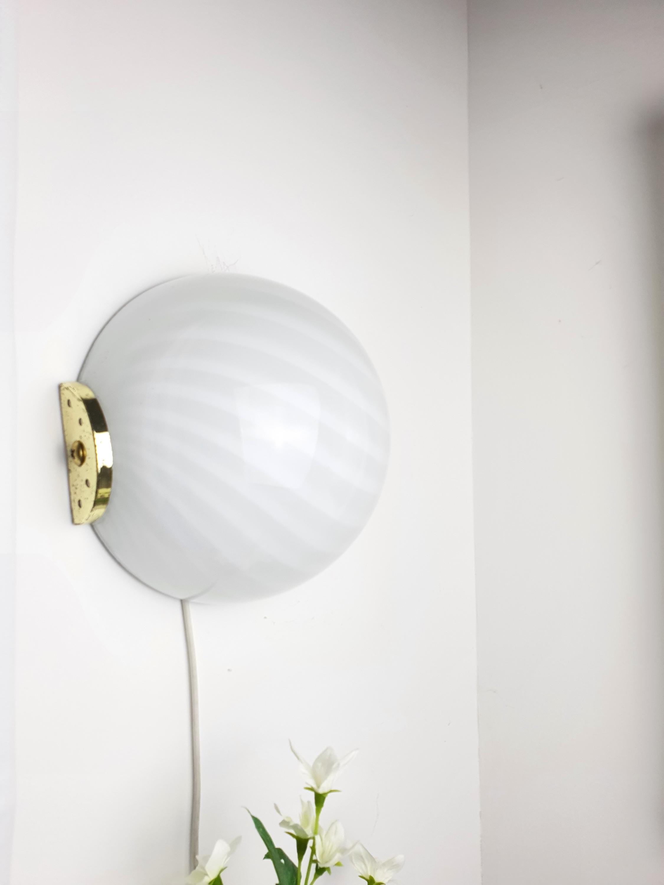 Close-up of white filigrana swirl pattern on vintage Murano glass shade, gold accent detail