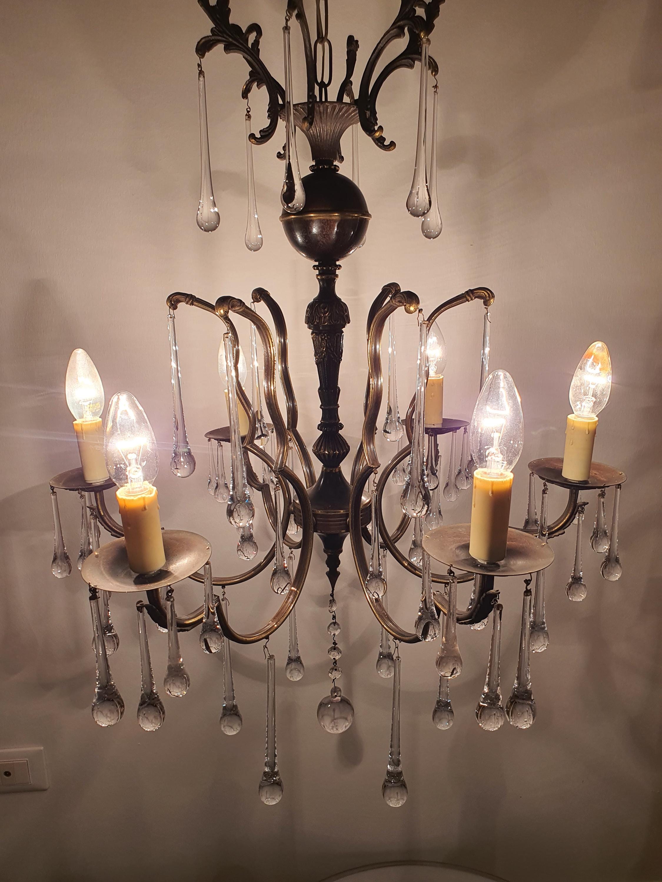 Vintage Italian brass Murano teardrop chandelier in grand entryway, cascading clear glass drops, Hollywood Regency statement