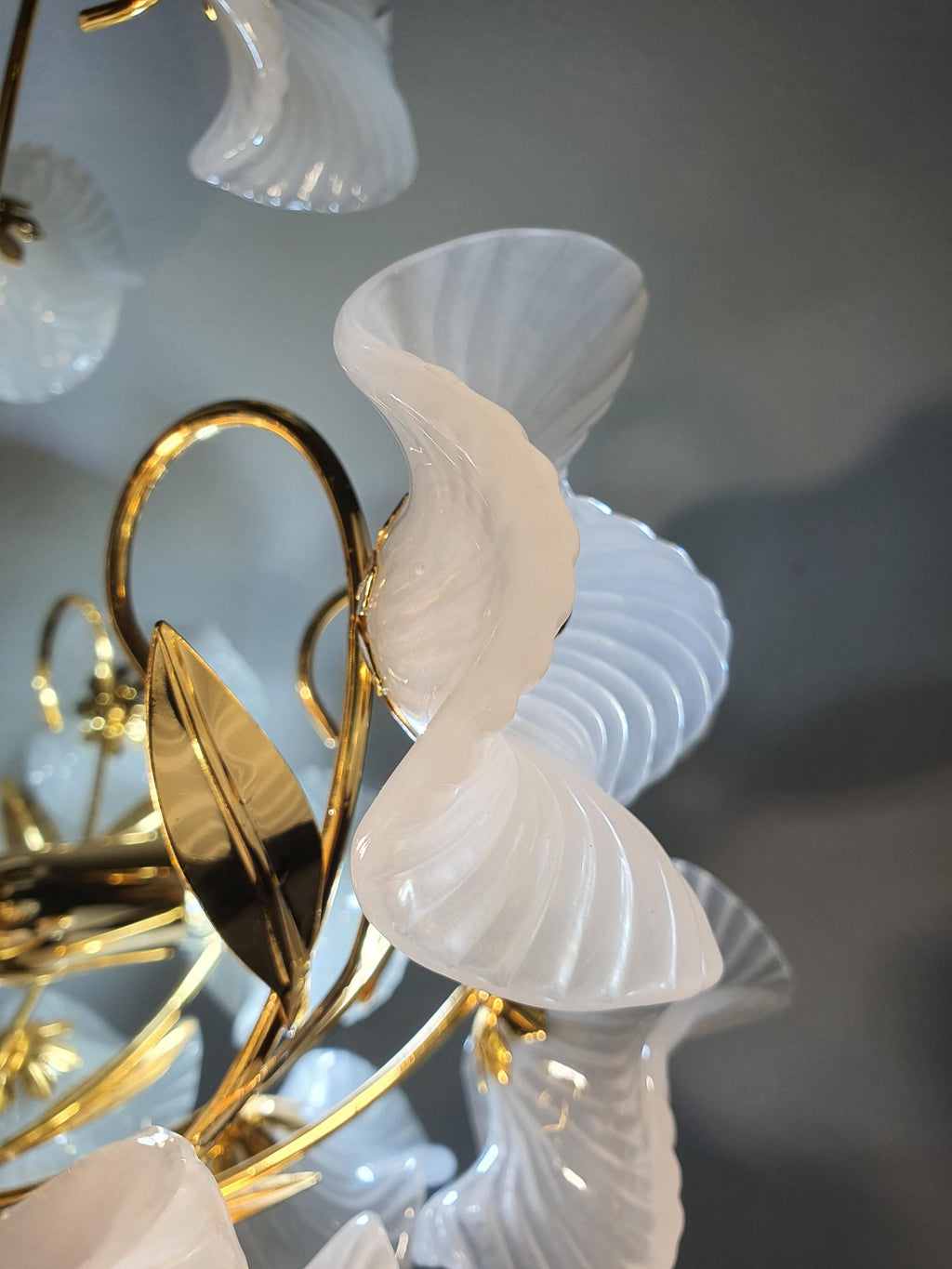 Close-up of ribbed semi-transparent white Murano glass flower petals on vintage bouquet chandelier, matte soft diffusion