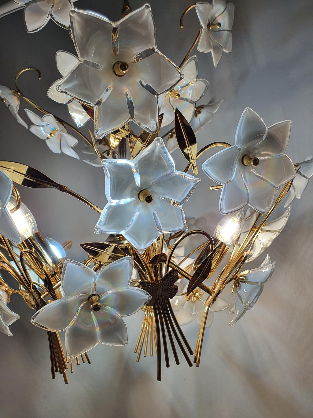 Vintage Murano floral chandelier lit, magical iridescent colour play through white flowers, soft atmospheric glow