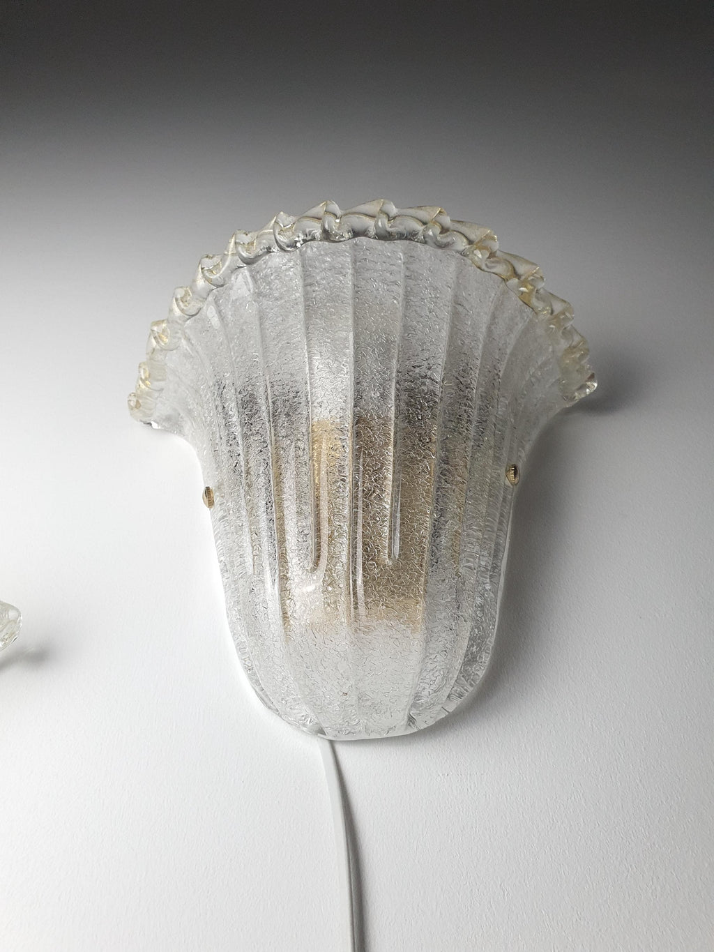Shell-shaped Murano glass wall sconce with a softly textured glass shade
