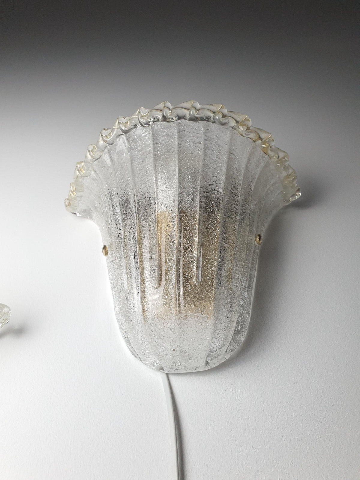 Shell-shaped Murano glass wall sconce with a softly textured glass shade
