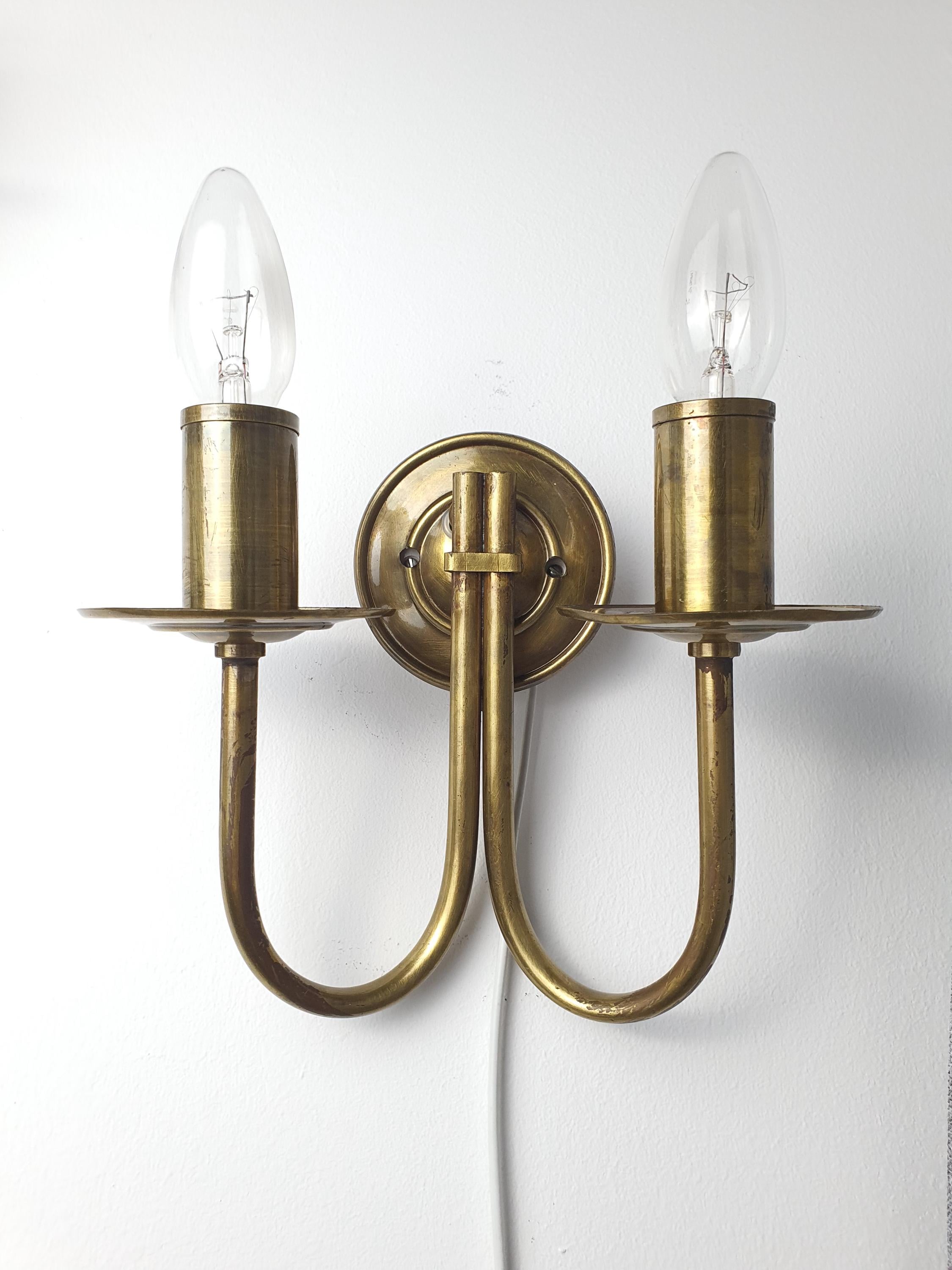 Vintage Italian double-arm lacquered brass wall sconce front view, two candle arms, natural brass patina, Art Deco silhouette