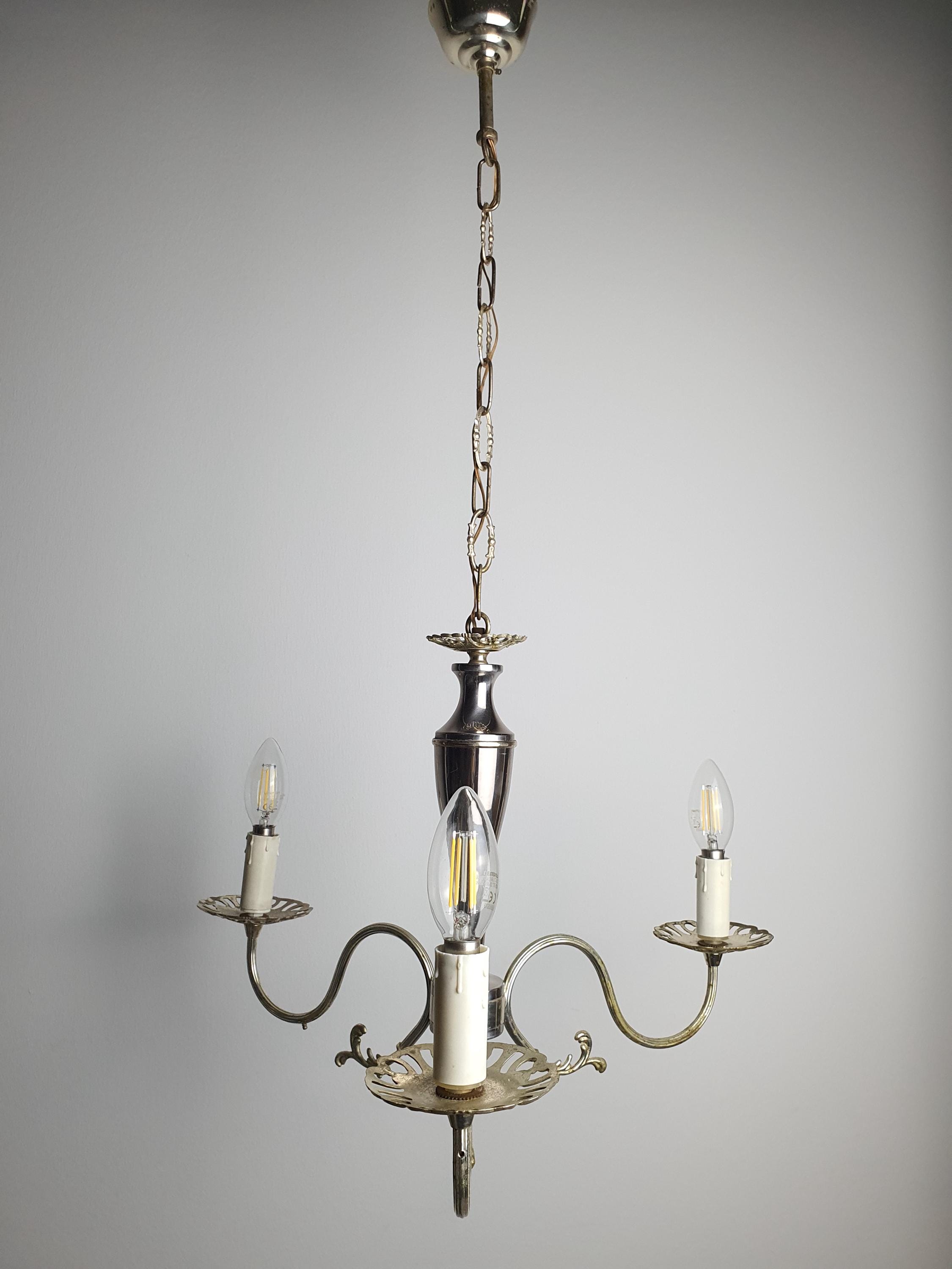 Vintage Italian silver-tone candle chandelier unlit, showing curved arm silhouette and patina texture