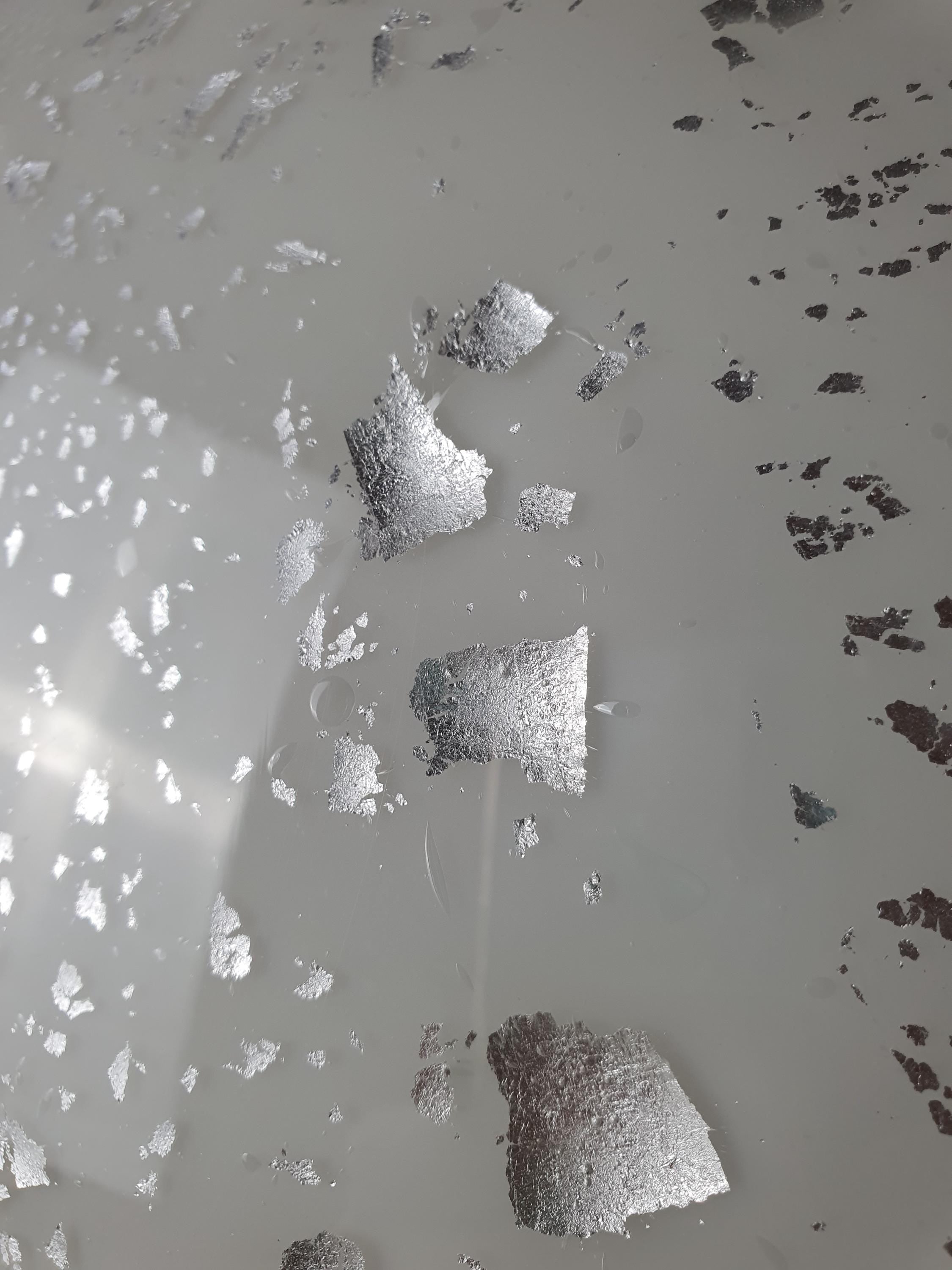Close-up of silver aventurine inclusions in vintage Murano white flush mount, varying flake sizes, constellation shimmer effect