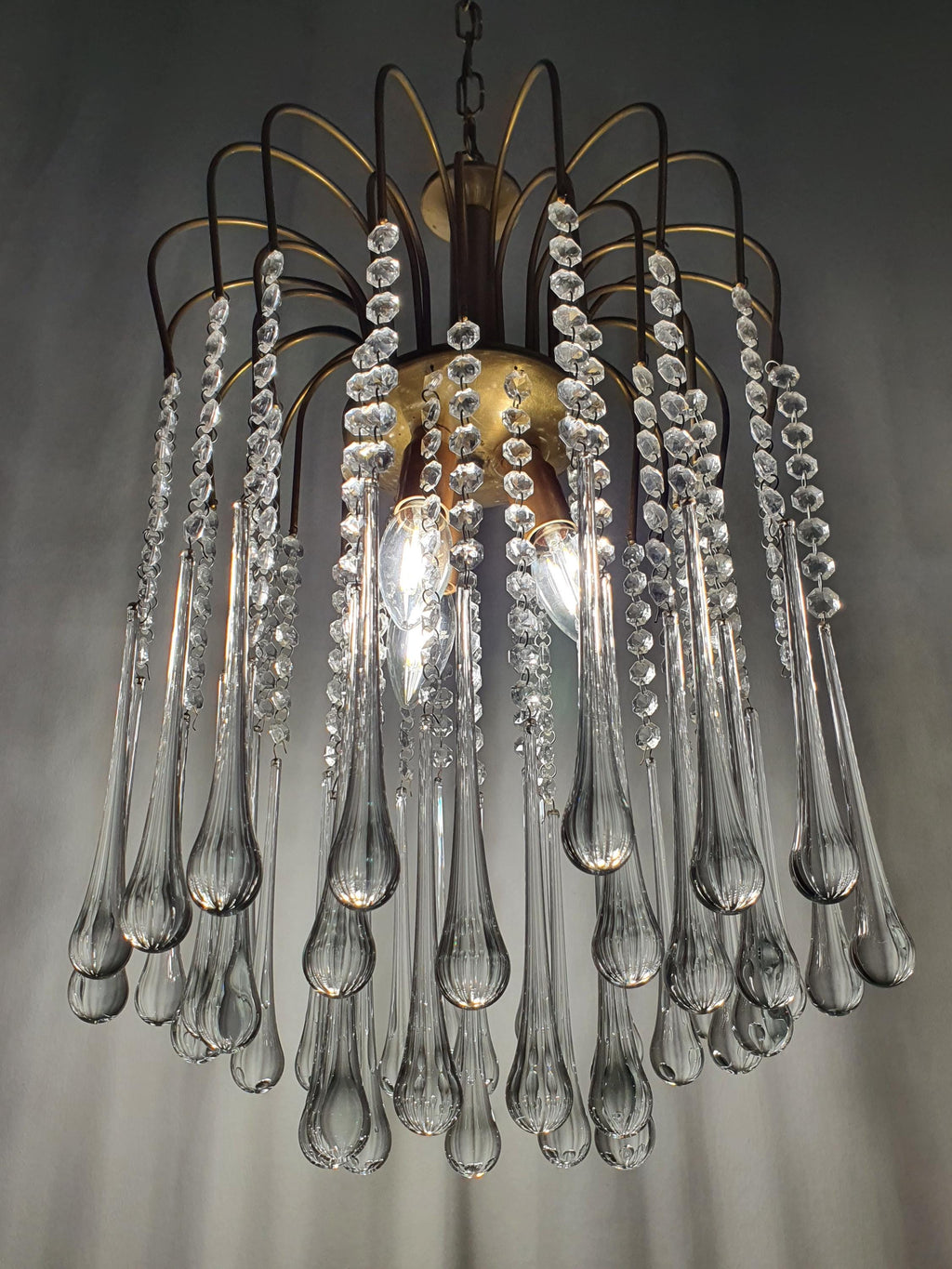 Vintage Murano glass chandelier — illuminated, delicate cascade shimmer filling the room