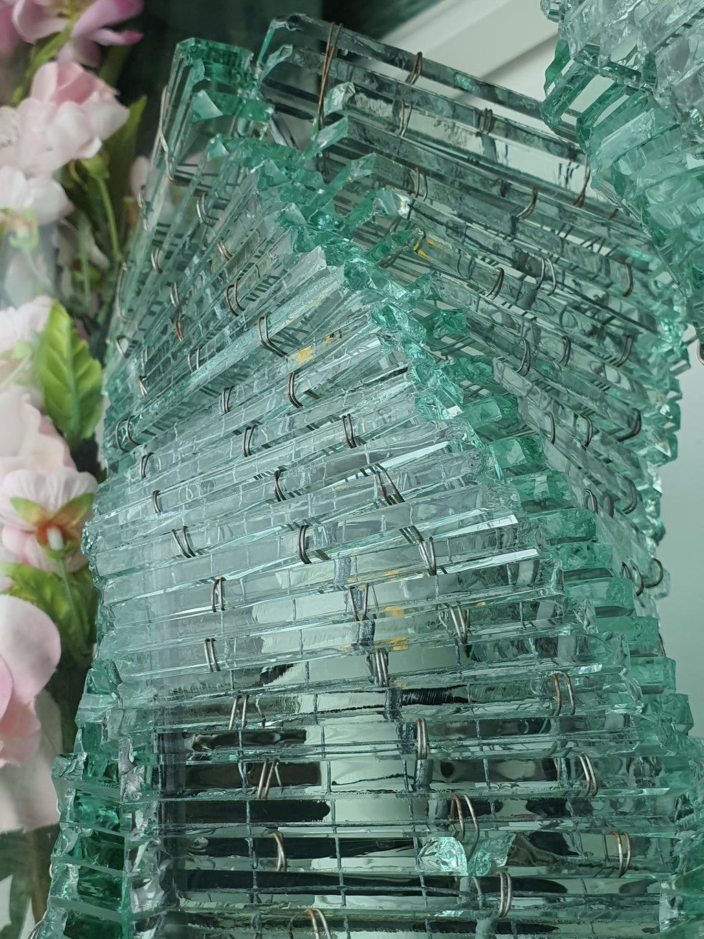 Individually assembled glass segments forming a spiral lamp column
