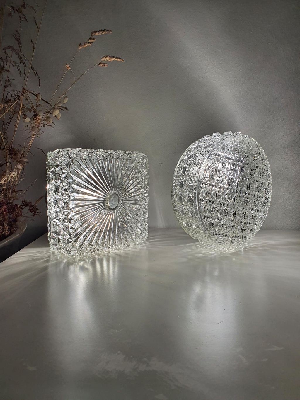 Set of two vintage clear glass wall sconces, one round and one square
