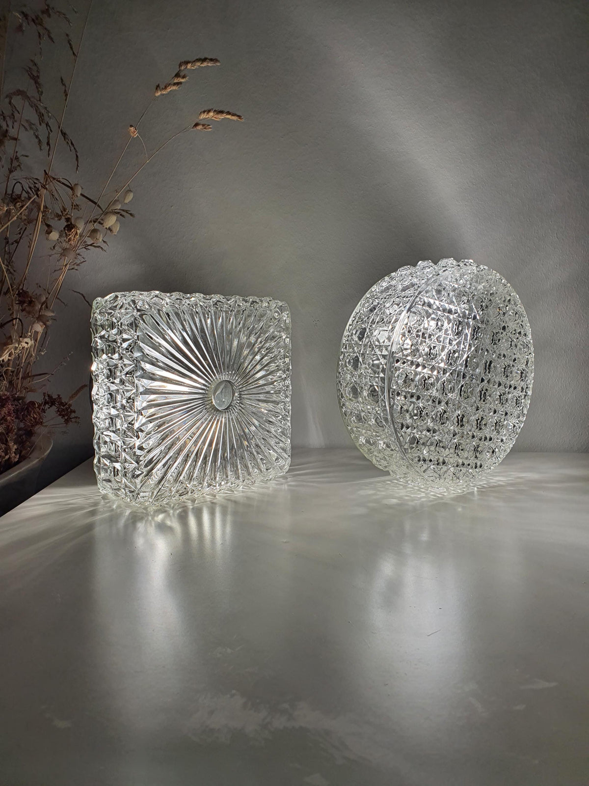 Set of two vintage clear glass wall sconces, one round and one square

