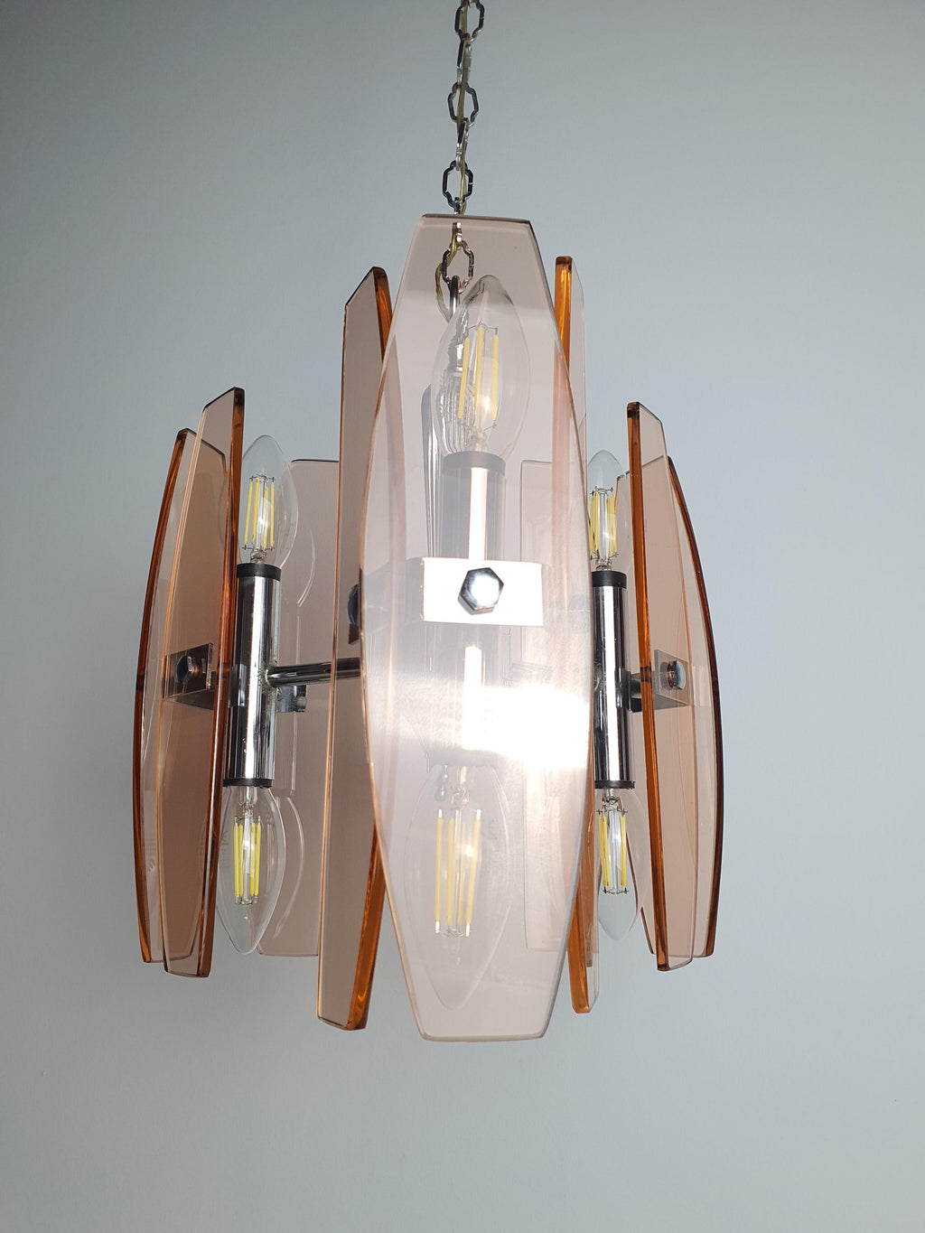 Veca pink glass chandelier — chrome base and upward-facing light detail