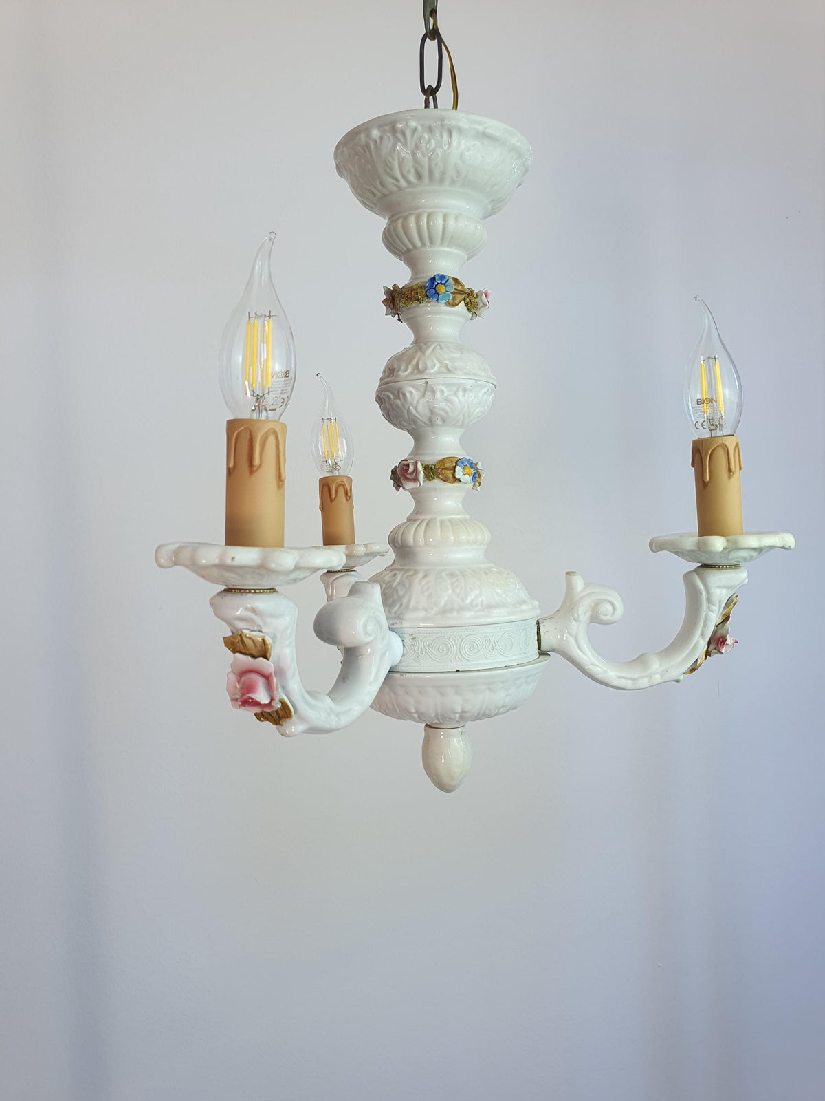 White ceramic chandelier with three curved arms and candle-style bulb holders
