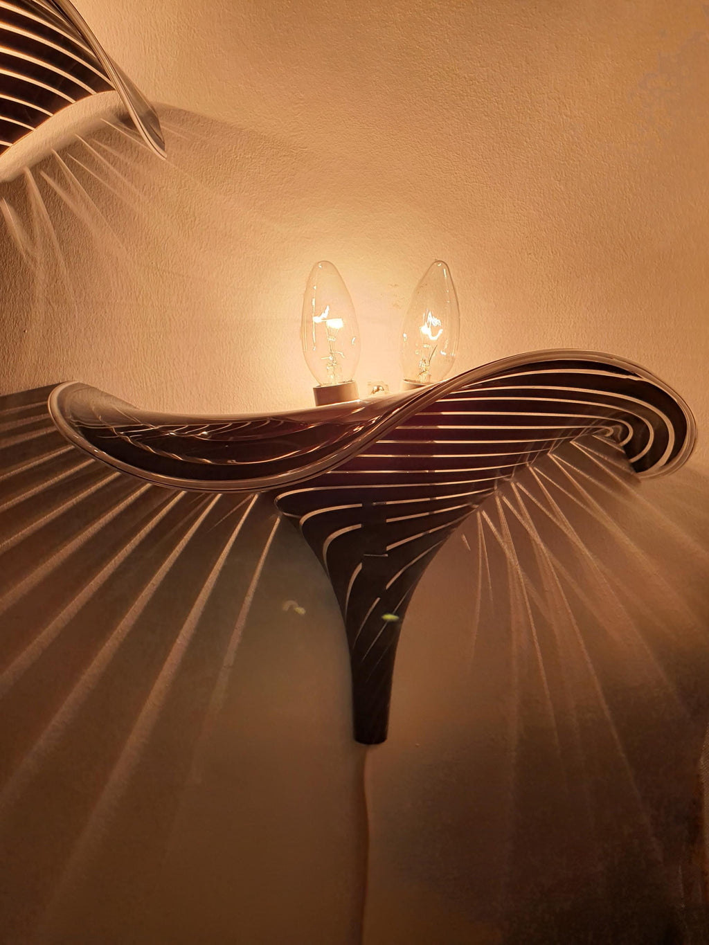 Pair of vintage Murano calla lily wall sconces in hallway, dramatic black stripe wave silhouette, Italian art glass statement