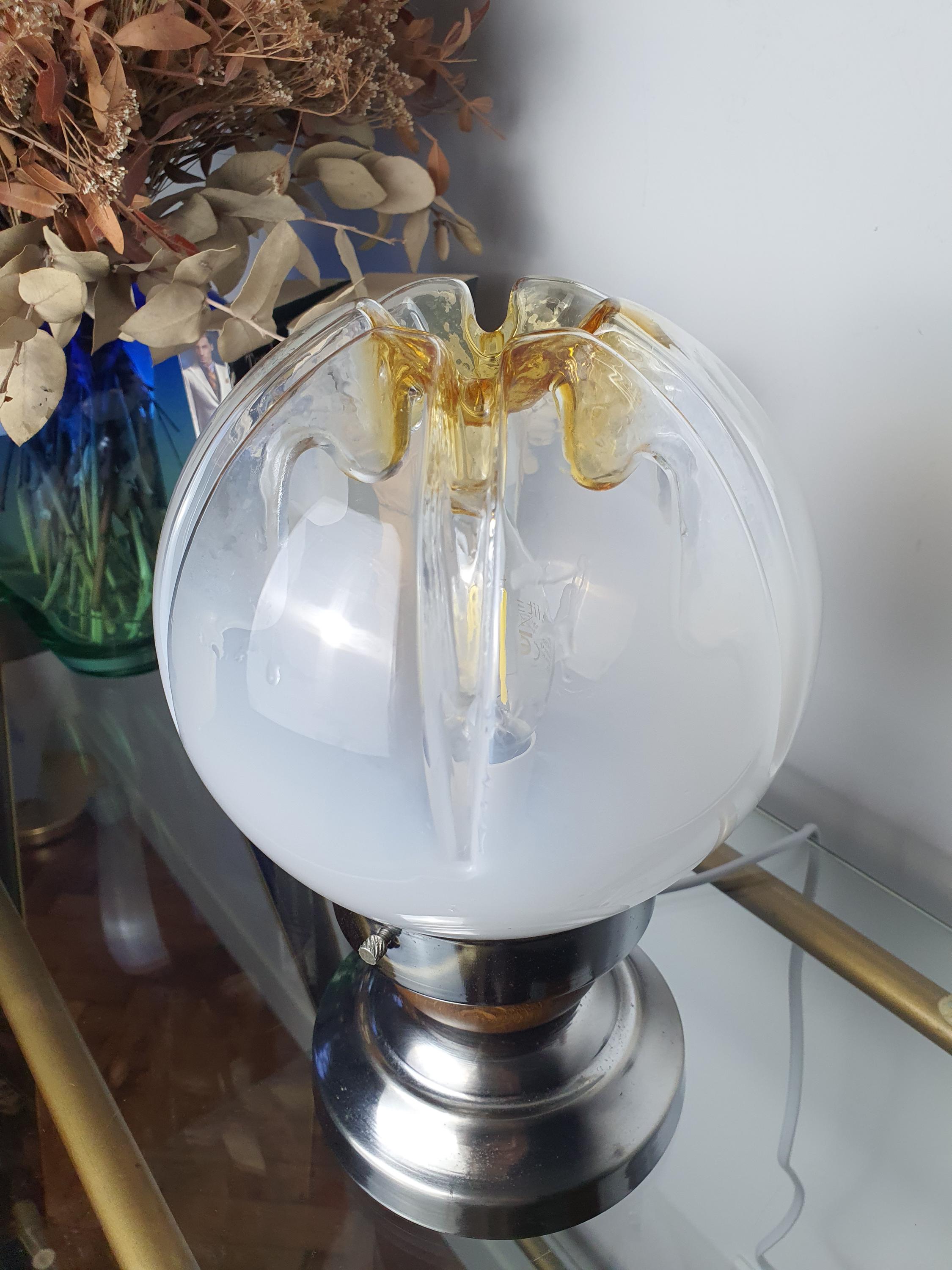 Close-up of inverse caramel drip relief on vintage Mazzega Murano glass globe, white-to-clear gradient, amber crown detail