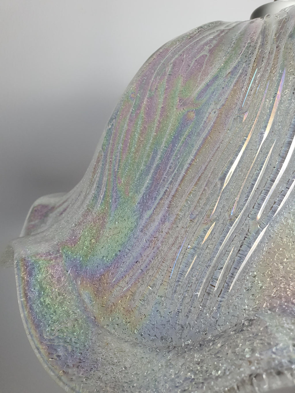 Close-up of iridescent rainbow finish on vintage Murano glass tulip pendant, petrol blue green violet pink gold hues