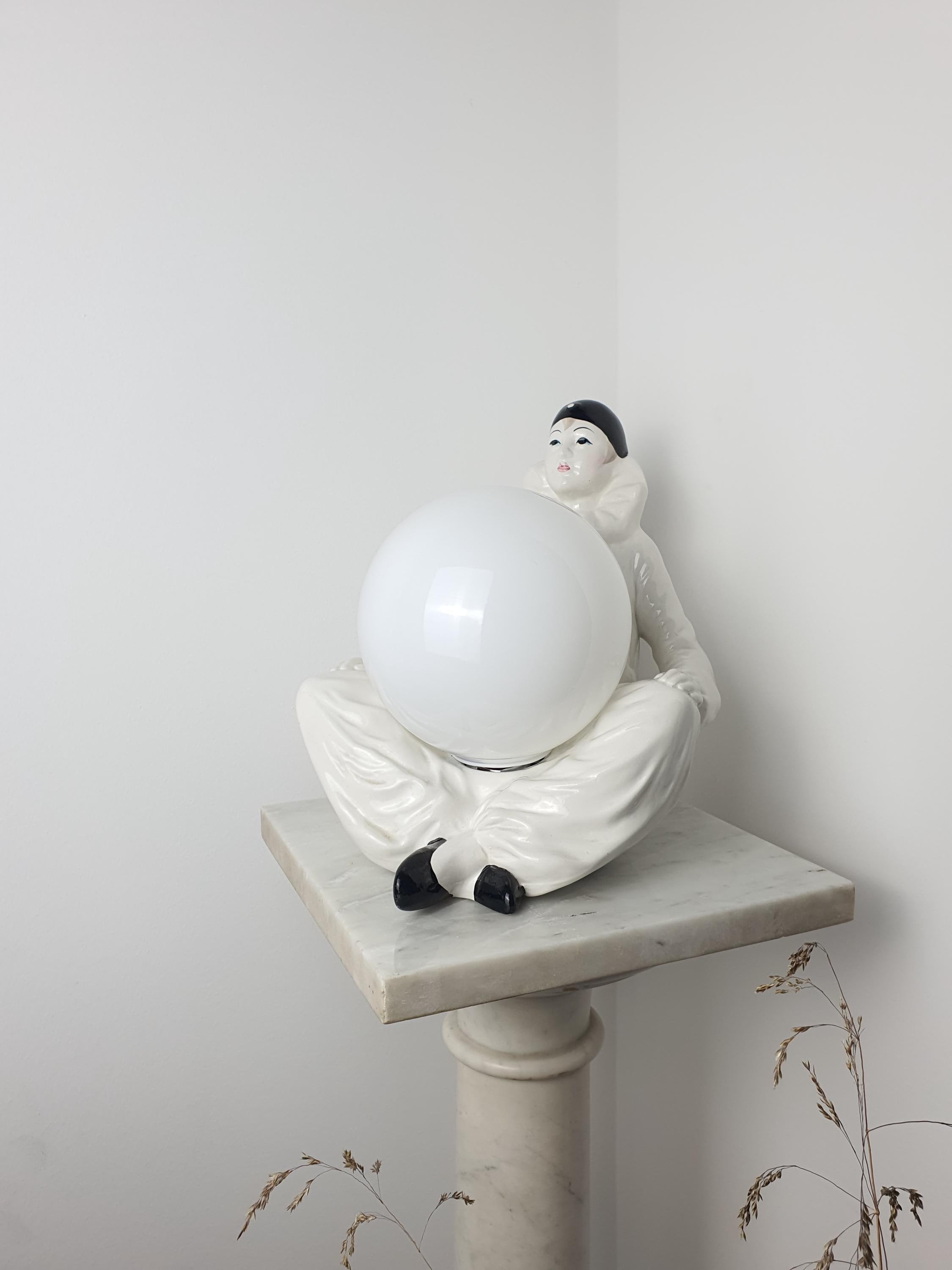 Vintage Italian Pierrot clown ceramic lamp unlit, showing full sad clown figurine silhouette and white globe shade
